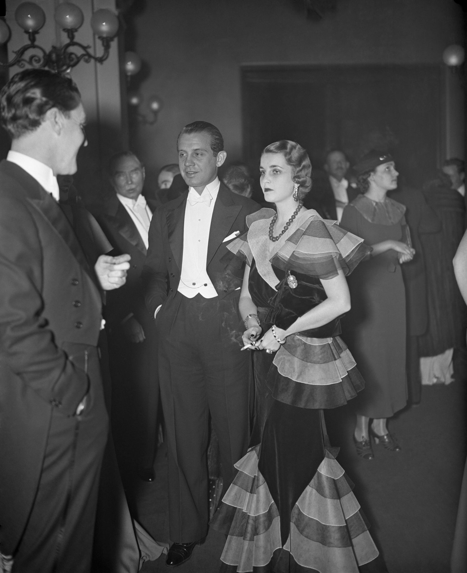 Prince and Princess Alexis Mdivani shown arriving at the Metropolitan Opera House, New York, December 26th, for the opening of the opera season. Princess Mdivani is the former Barbara Hutton.