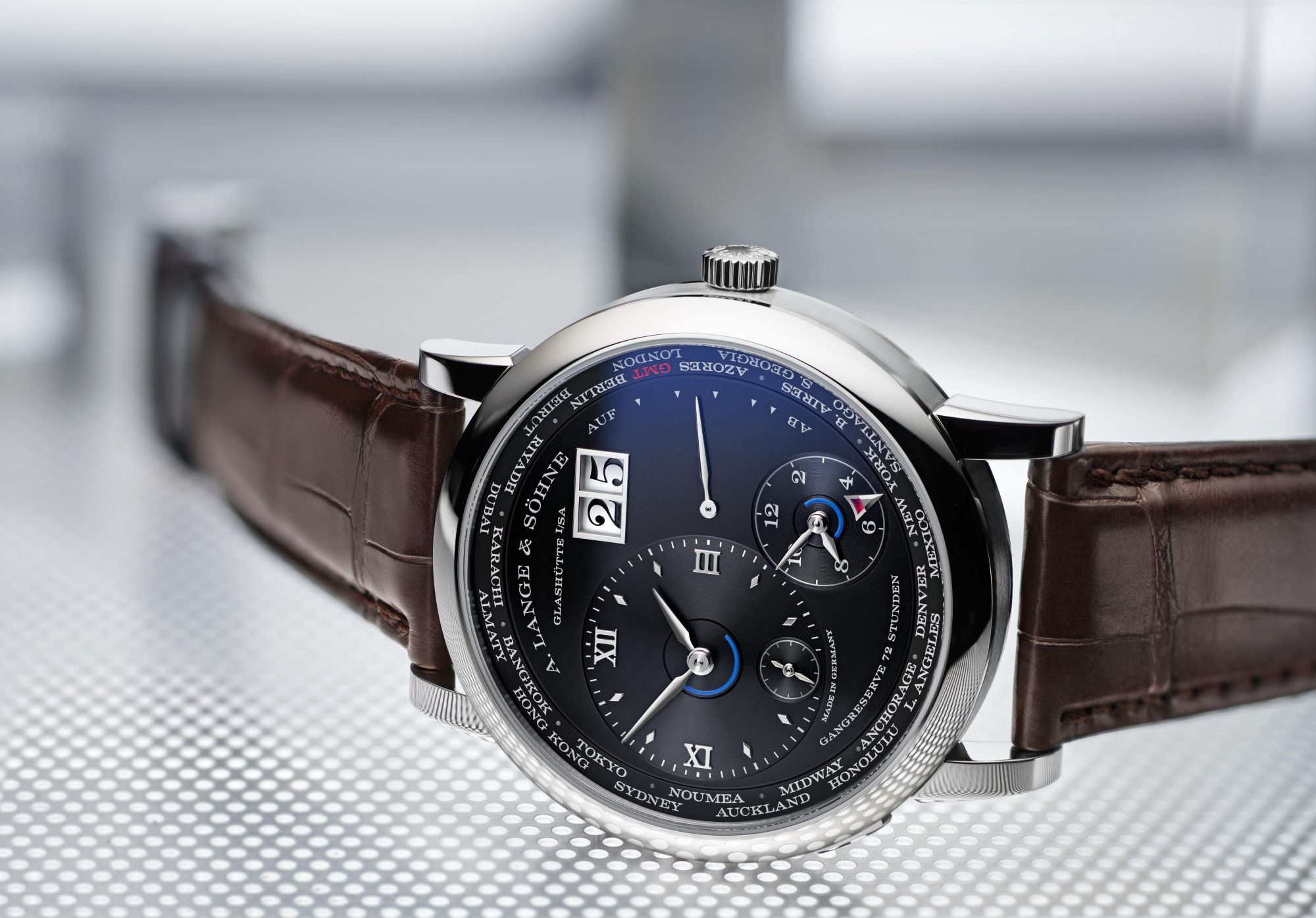 The new edition of the LANGE 1 TIME ZONE, presented in June 2020 and equipped with a new manufacture calibre L141.1, combines functionality with clear readability. The time and date at home and another of the 24 zone times can be read at one glance. Ring-shaped day/night indicators assure good legibility and the new daylight saving time indication is a useful addition.The model in white gold is equipped with a black dial and a dark brown leather strap. It measures 41.9 mm in diameter and is 10.9 mm high.