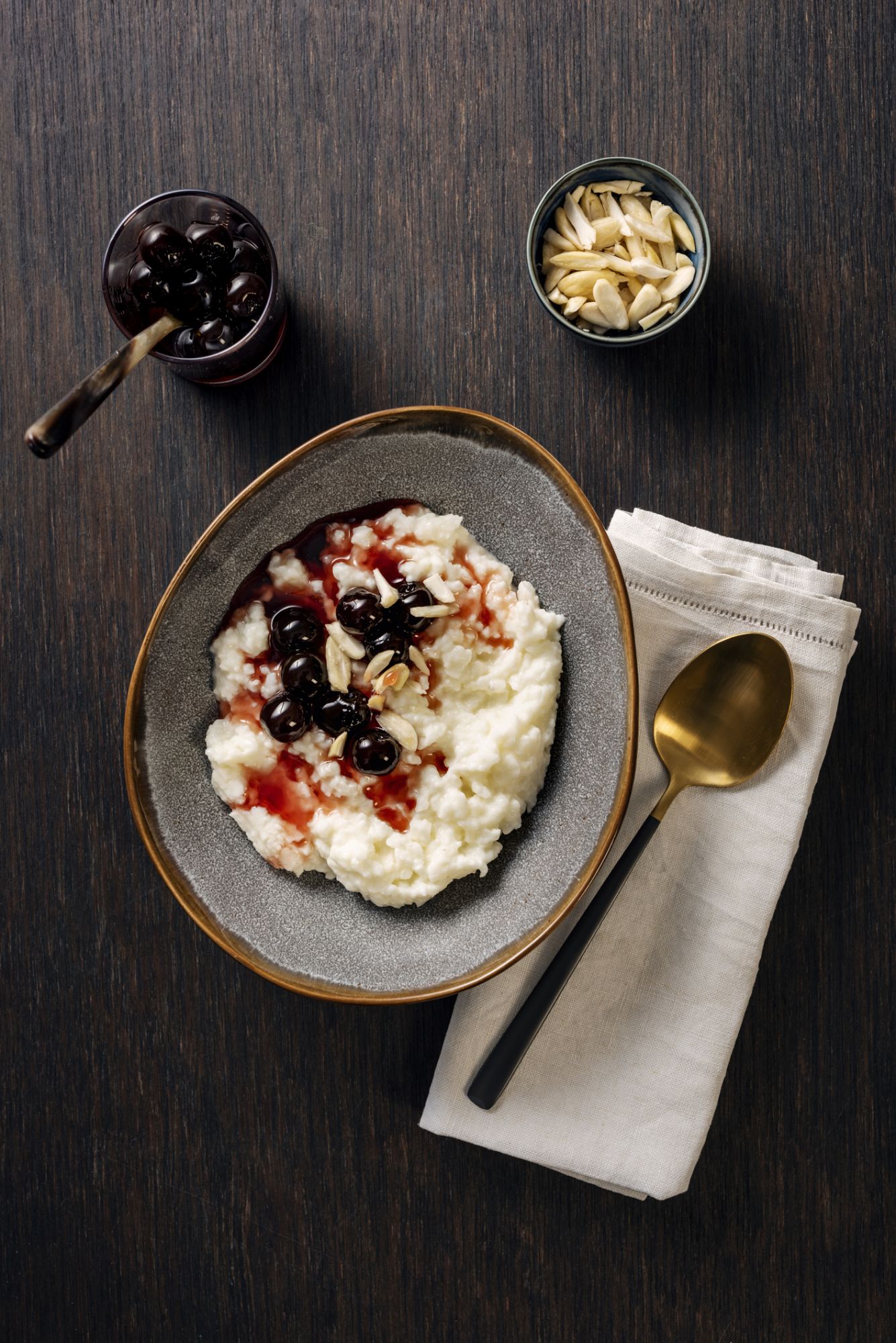 Overhead view of a traditional danish rice pudding or risalamande dessert served at Christmas time in Denmark and in other parts of Scandinavia. It is traditionally served with a rich cherry sauce and chopped almonds. Usually there is a small silver coin hidden in the dessert that one lucky child will hopefully find.