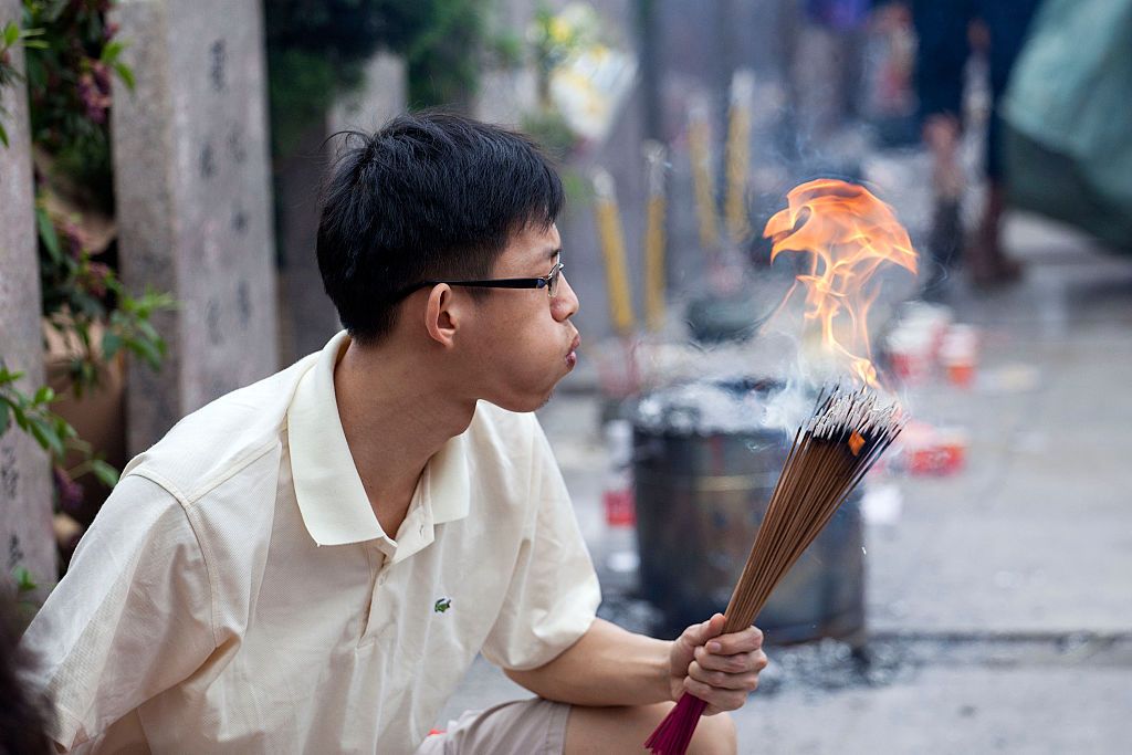 GUANGZHOU, CHINA - APRIL 05: (CHINA OUT) People mourn their ancestors and the deceased at a cemetery during Qingming Festival (also known as Tomb-sweeping Festival) on April 5, 2015 in Guangzhou, Guangdong province of China. Chinese traditional Qingming Festival, or "Tomb-sweeping Day", which is on April 5 theis year according to Chinese calendar, is a traditional time when people worship the deceased and ancestors, involving cleaning and repairing tombs and other sacrifice activities. (Photo by Visual Ch