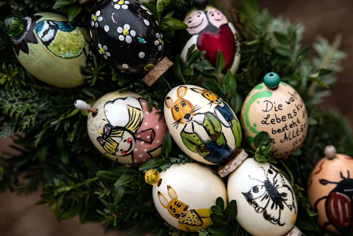 28 March 2021, Lower Saxony, Gieboldehausen: Colourfully painted eggs with various motifs on fresh greenery decorate a fountain. Originally from Franconian Switzerland, the custom of decorating Easter fountains in the time before Easter has become established. Photo: Swen Pförtner/dpa (Photo by Swen Pförtner/picture alliance via Getty Images)