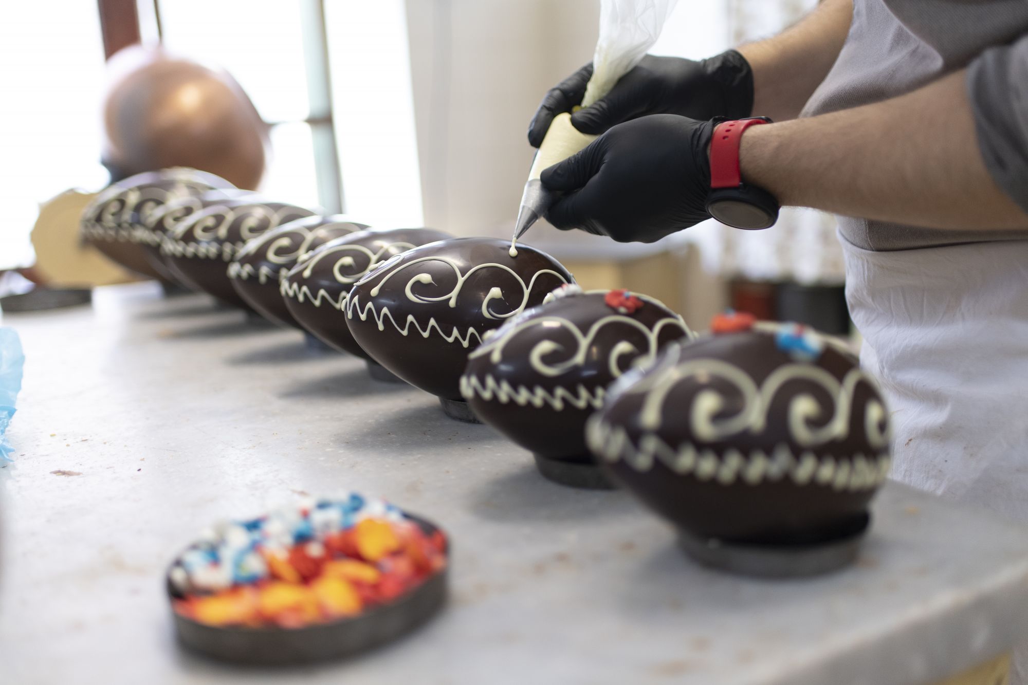 TURIN, ITALY - APRIL 02: Hands of Artisan chocolatier, Luca Croci, decorates the chocolate Easter eggs are produced in the chocolate laboratory on April 02, 2021 in Turin, Italy. Since the 1930s, the Croci family's artisan laboratory in Turin has been producing high quality chocolate Easter eggs. (Photo by Stefano Guidi/Getty Images)
