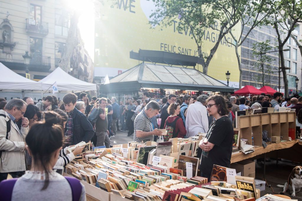 People look at books on the Ramblas boulevard during Sant Jordi festivities in Barcelona on April 23, 2018, on Saint George's day. - Traditionally men give women roses and women give men a book to celebrate the Catalan holiday also know as 'The Day of the Rose' or 'The Day of the Book.  (Photo by Xavier Bonilla/NurPhoto via Getty Images)