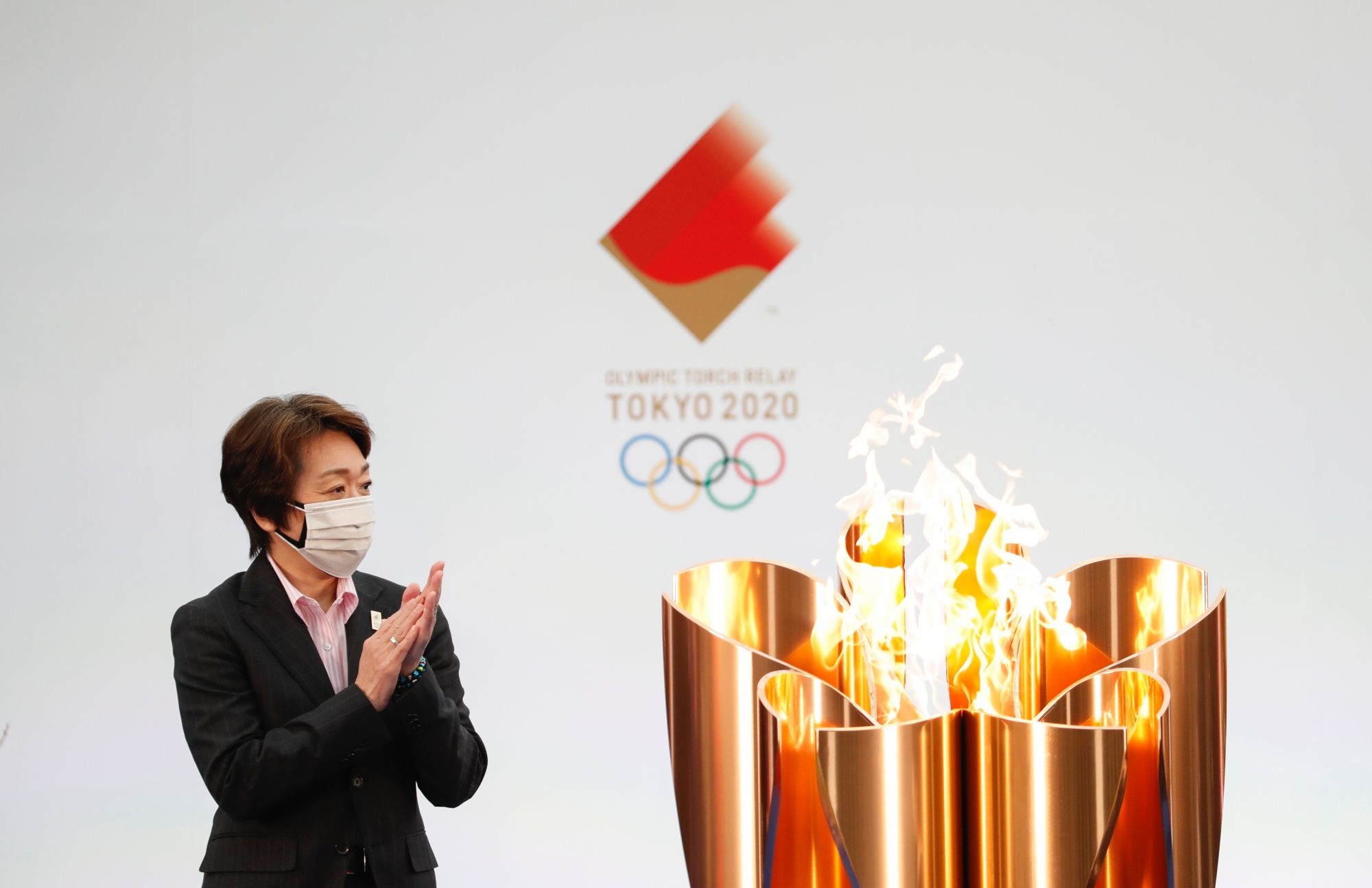 NARAHA, JAPAN - MARCH 25: Tokyo 2020 President Seiko Hashimoto applauds next to the celebration cauldron during the opening ceremony ahead of the the first day of the Tokyo 2020 Olympic torch relay at the J Village during the Tokyo Olympic Games torch relay on March 25, 2021 in Naraha, Fukushima, Japan. (Photo by Kim Kyung-Hoon - Pool/Getty Images)