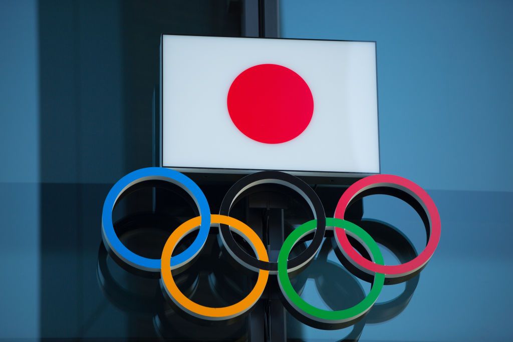SHINJUKU, TOKYO, JAPAN - 2020/03/19: Japanese National Flag over the Olympic Rings symbol is seen at the entrance of the Japan Olympic Museum in Shinjuku. Japanese start thinking that it would be the best to postpone the Tokyo 2020 Olympic and Paralympic Games due to the fear of spreading the Covid-19 Coronavirus more into its population. (Photo by Stanislav Kogiku/SOPA Images/LightRocket via Getty Images)