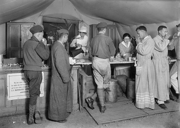 American Soldiers en route to the front being served daily with Coffee and Doughnuts at the American Red Cross Canteen, St-Pierre des Corps, Tours, France, Lewis Wickes Hine, American National Red Cross Photograph Collection, September 1918. (Photo by: Universal History Archive/Universal Images Group via Getty Images)