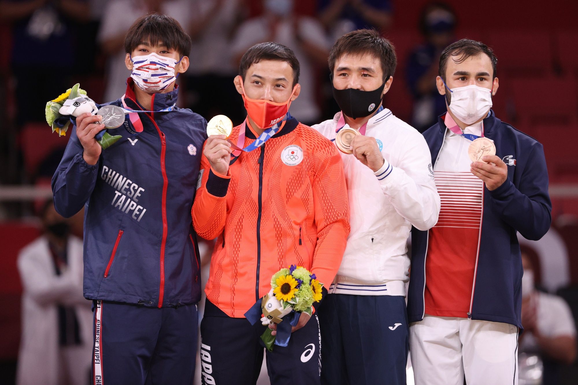 TOKYO, JAPAN - JULY 24: Silver medallist Wei Yung Yang of Chinese Taipei, gold medallist Naohisa Takato of Team Japan, bronze medallist A, Yeldos Smetov of Kazakhstan and bronze medallist B, Luka Mkheidze of Team France pose on the podium for the Menâs Judo 60kg Final on day one of the Tokyo 2020 Olympic Games at Nippon Budokan on July 24, 2021 in Tokyo, Japan. (Photo by Harry How/Getty Images)