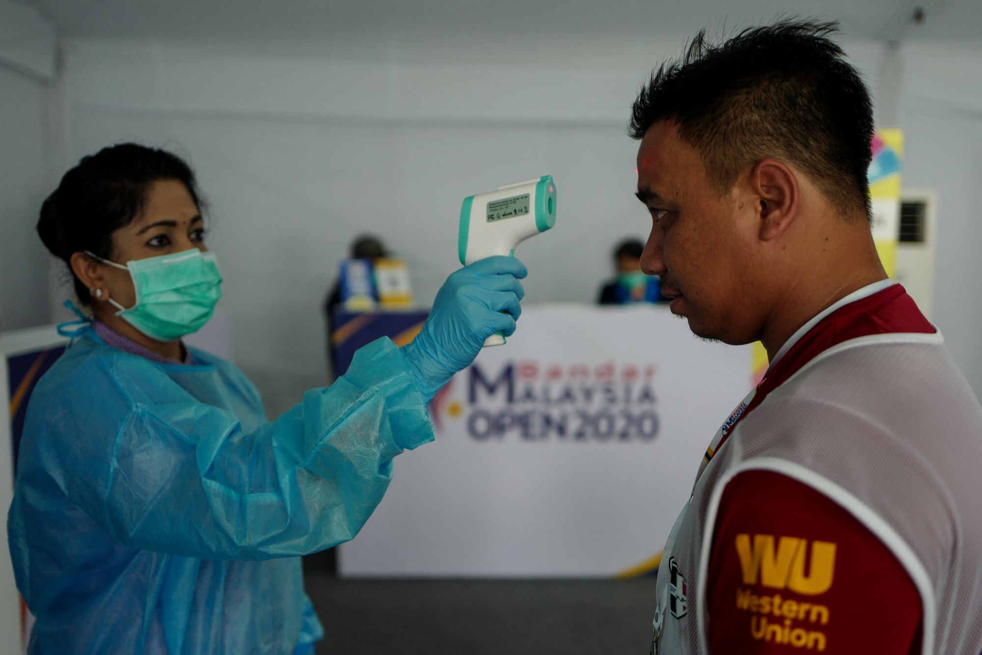 SHAH ALAM, MALAYSIA - MARCH 07: Medical personnel wearing face mask and protective clothing measures the temperature of a press photographer using the forehead thermometer as a precautionary measure against the spread of the new coronavirus (COVID-19) during Bandar Malaysia Open at Kota Permai Golf and Country Club on March 07, 2020 in Shah Alam, Malaysia. (Photo by Sadiq Asyraf/Getty Images)