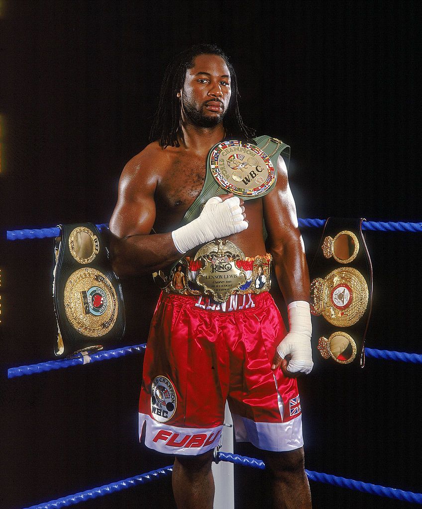 24 Jul 2000: World Heavyweight Champion Lennox Lewis of Great Britain shows off his IBO, WBC and WBA title belts during a feature shoot in London. \ Mandatory Credit: John Gichigi /Allsport