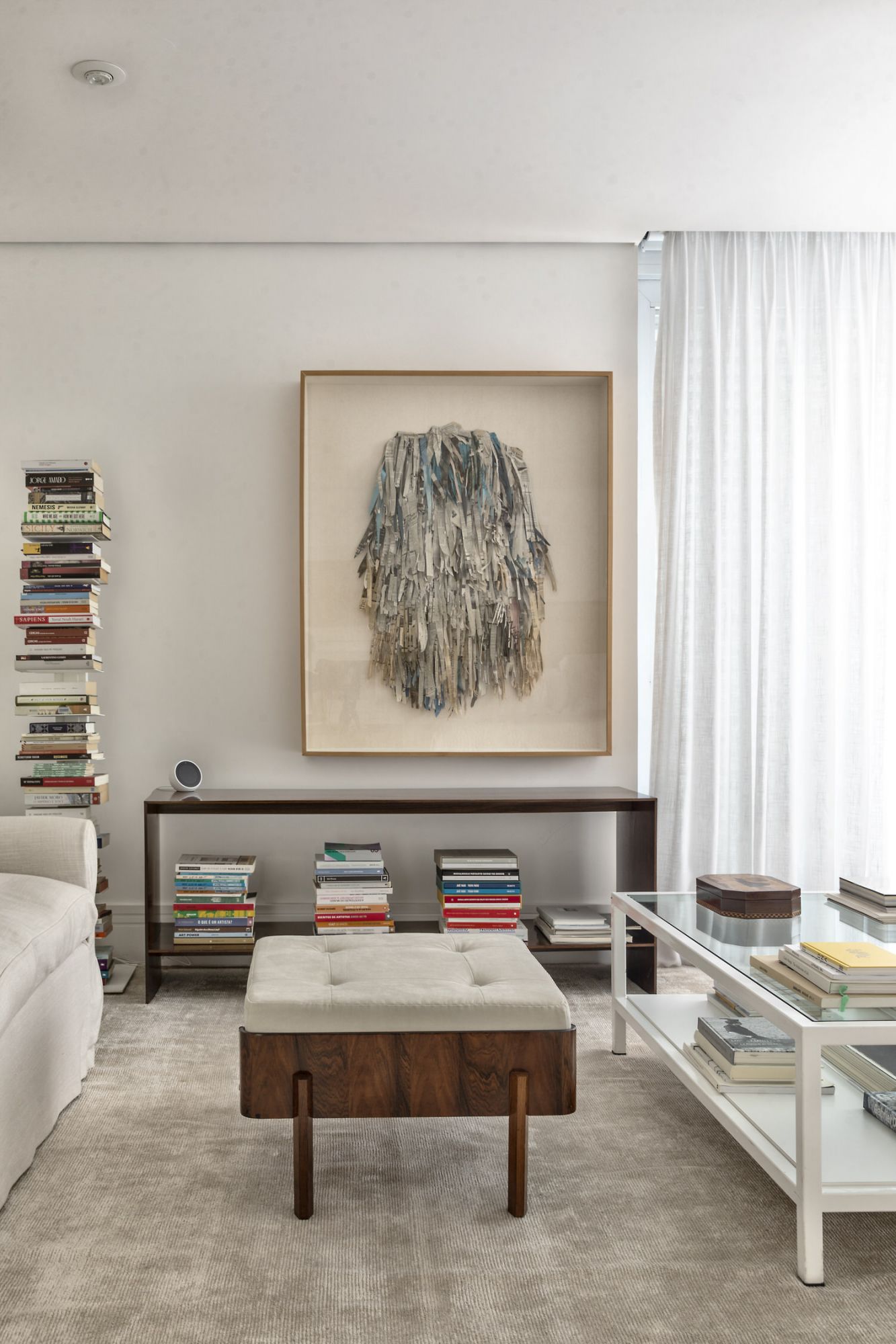 An artwork by Sara Ramos hangs above a wooden console by Joaquim Tenreiro