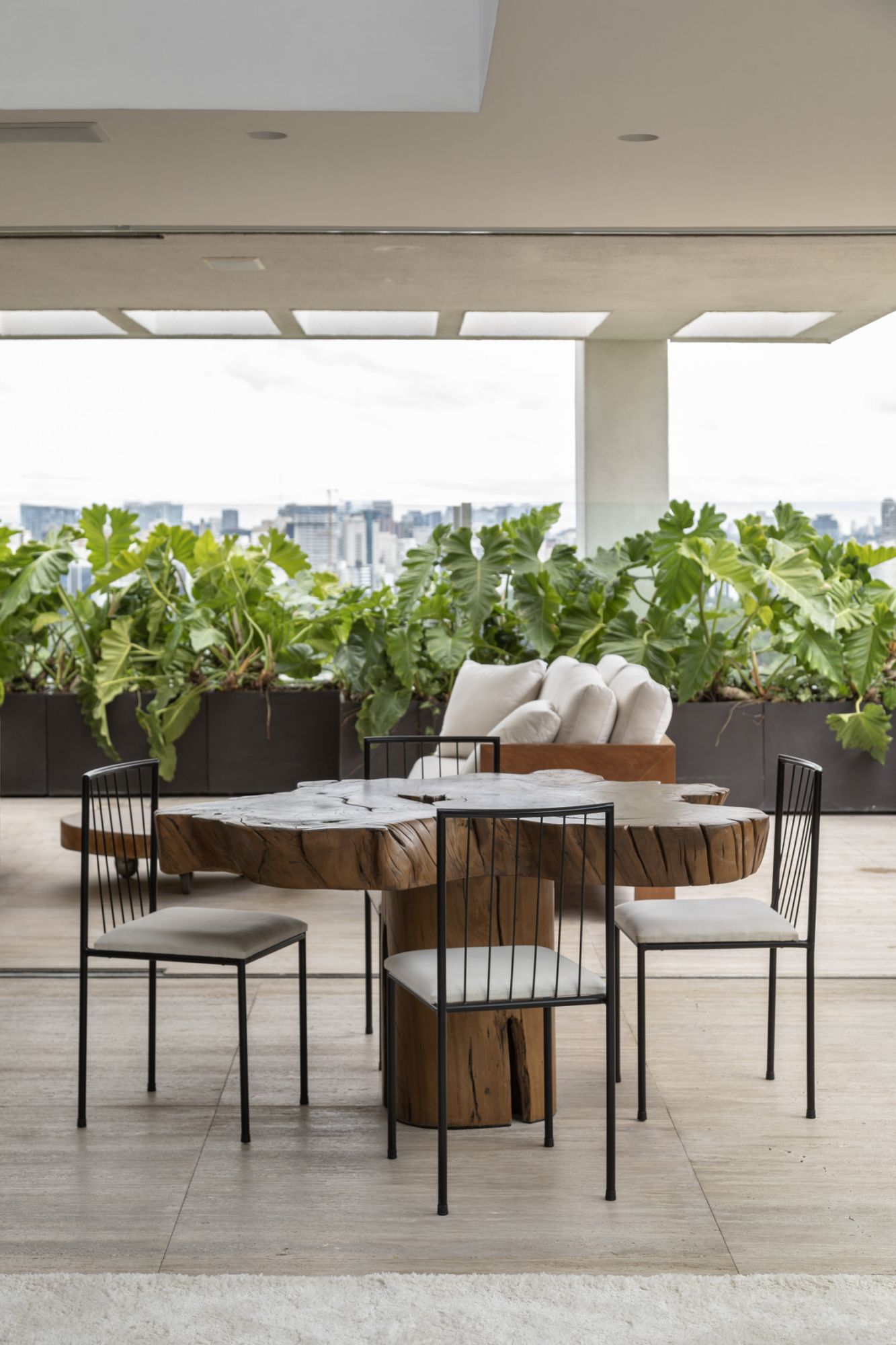 A small dining area, with a table by Hugo Franca and chairs by Geraldo de Barros, offers a scenic spot for guests to gather