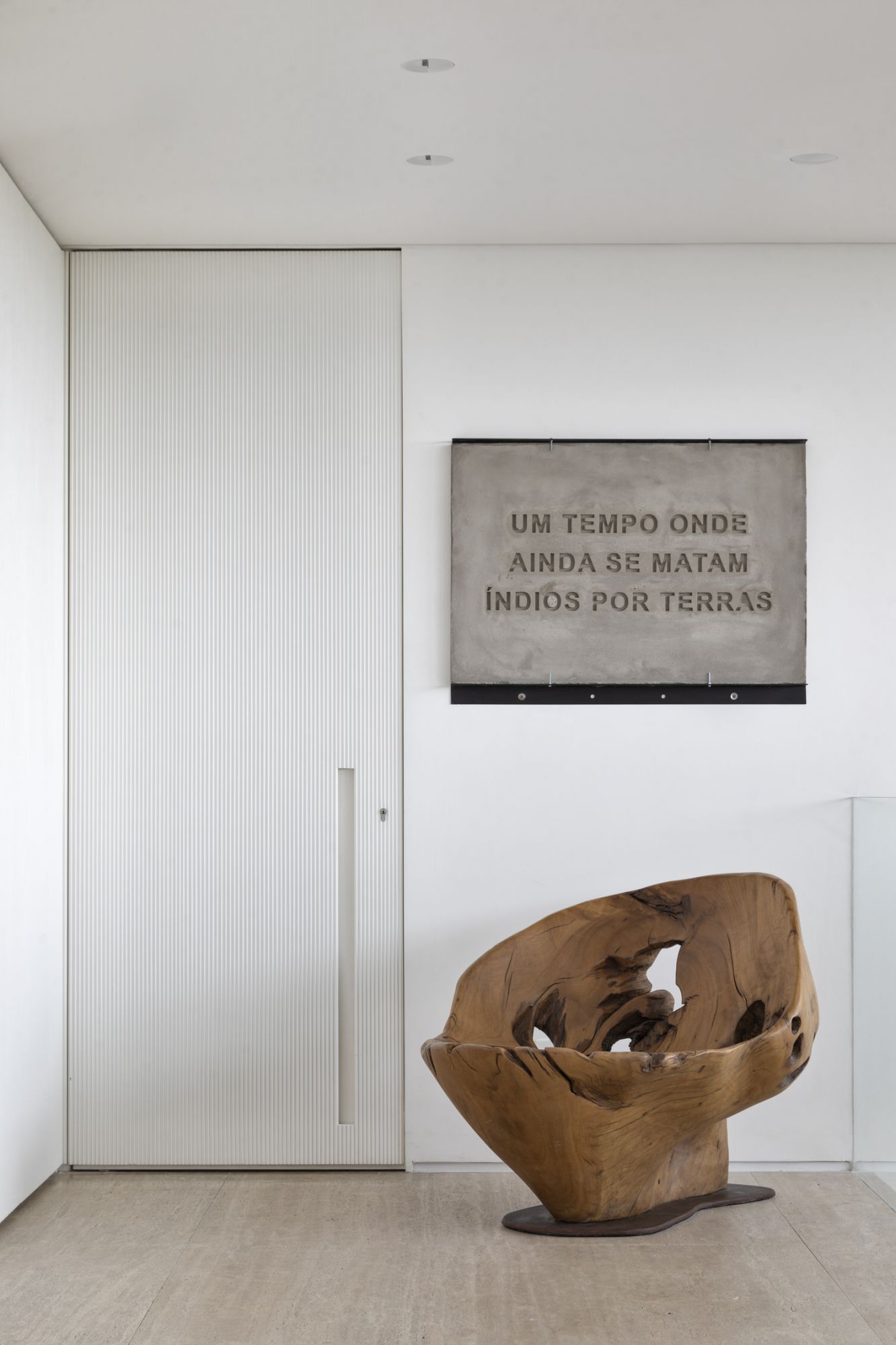 A cosy nook features a statement art piece by Jonathan de Andrade and a chair by Hugo Franca