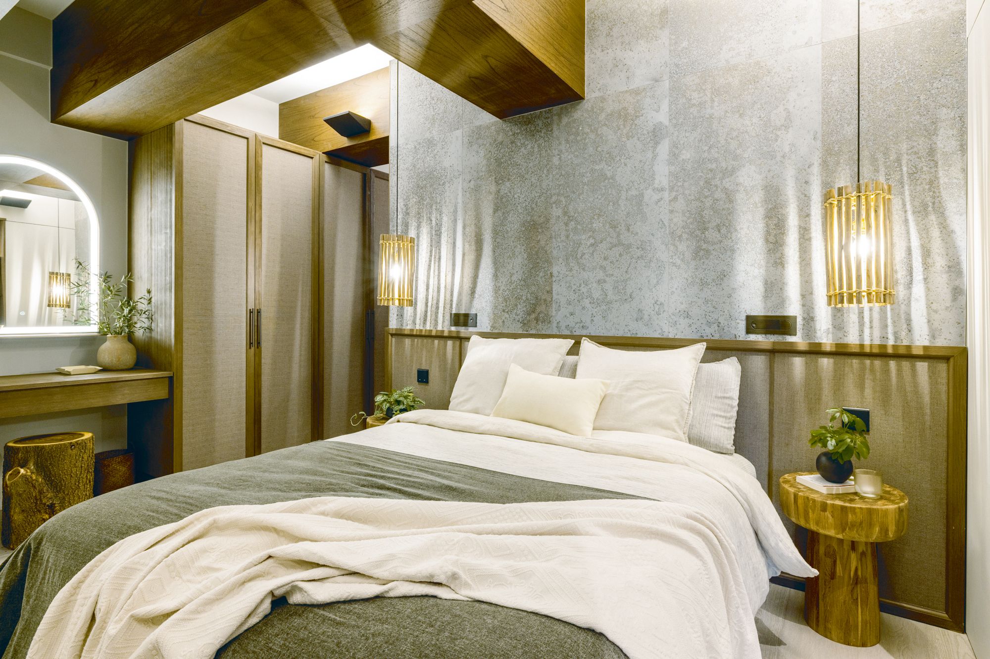 Textural bedlinen and wooden furnishings contribute to the cosy ambience of a bedroom designed by Liquid Interiors