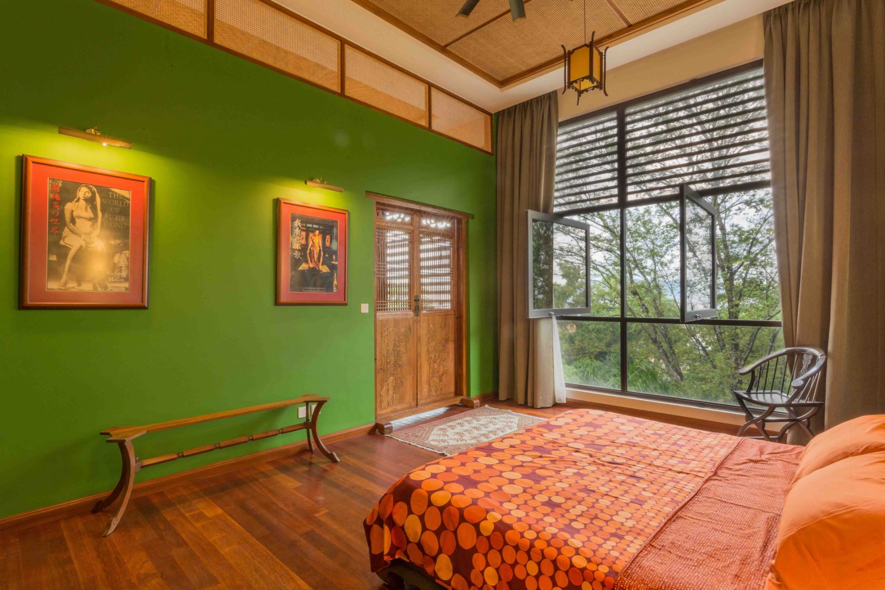 Bold green walls reflect the surrounding natural greenery in the master bedroom