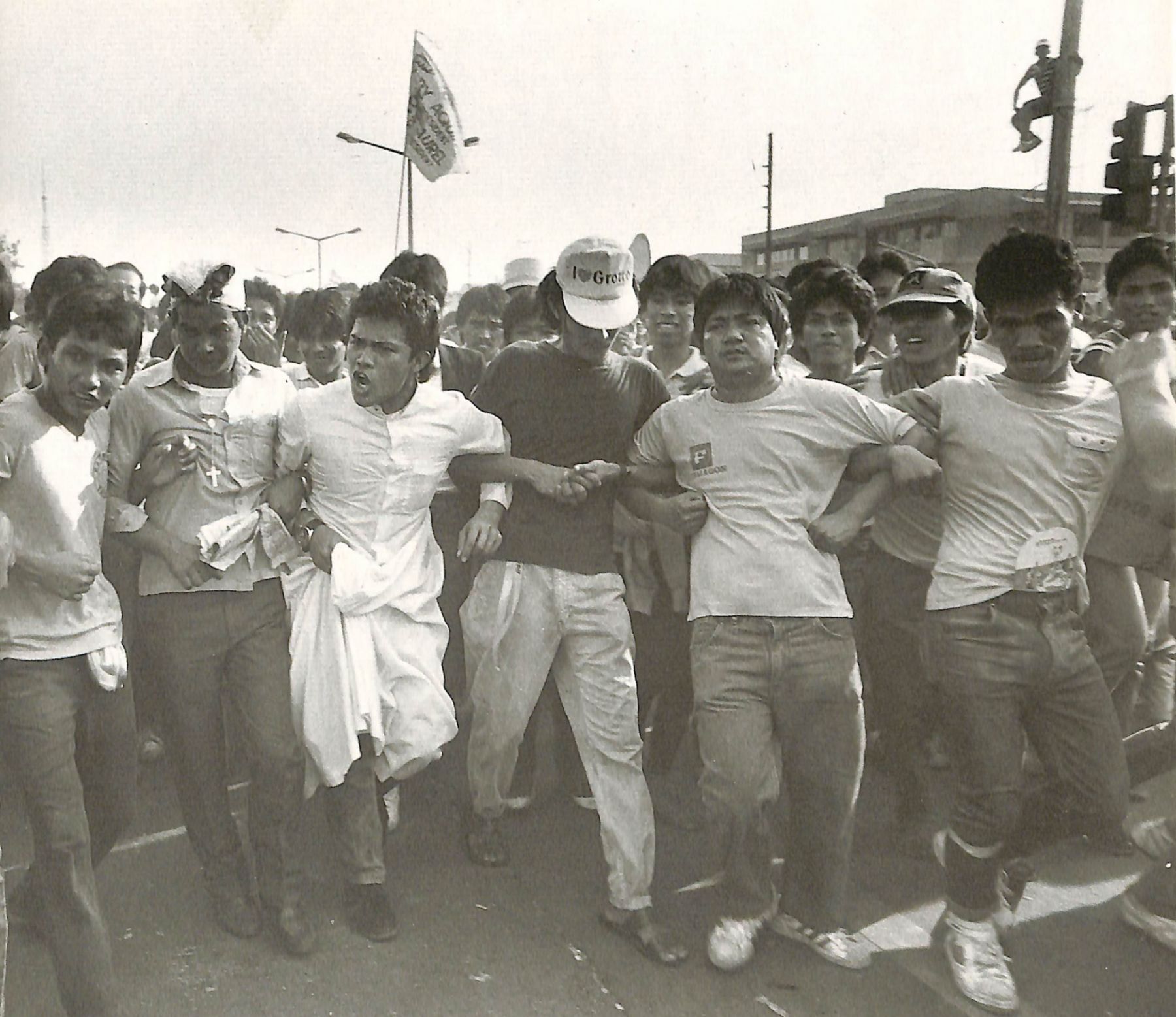 Arms linked, men face the tanks as some of them cry out to the Marines: "We are all Filipinos. Are you going to shoot fellow Filipinos?" ┃Photo: Presidential Museum And Library on Flickr