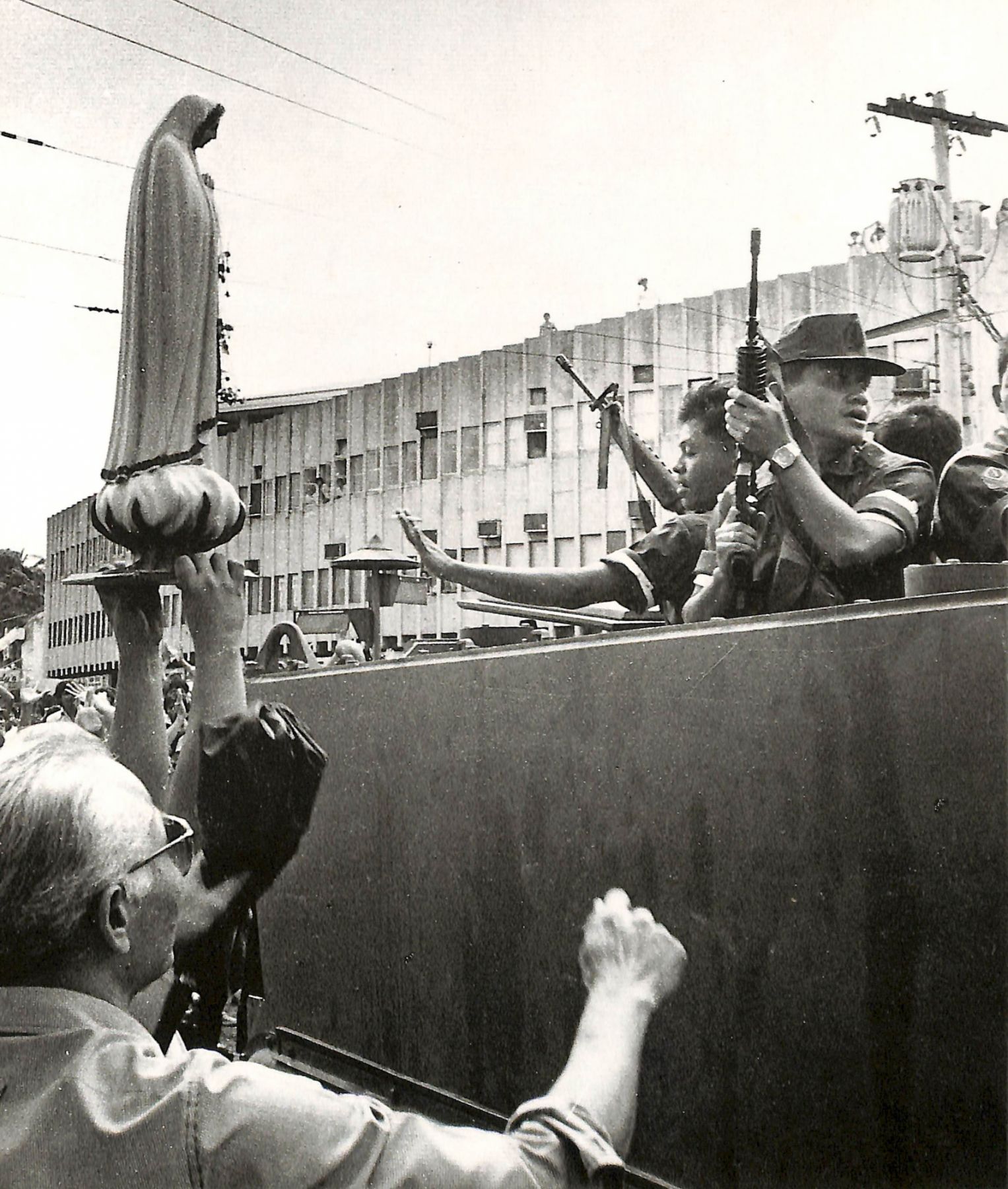 Emboldened and with one of them carrying a statue of the Blessed Virgin Mary, the people surround an armored personnel carrier ┃Photo: Presidential Museum And Library on Flickr