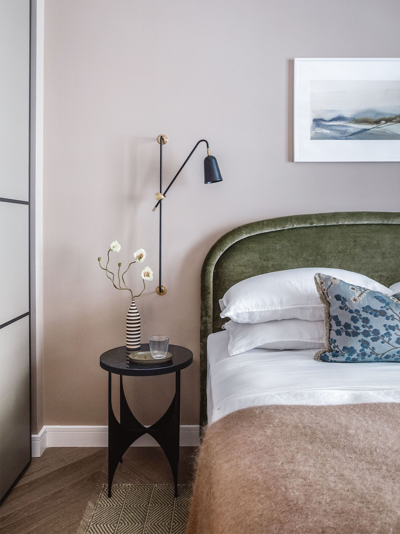 Blush pink walls and an earthy palette contribute to this bedroom’s soothing ambience