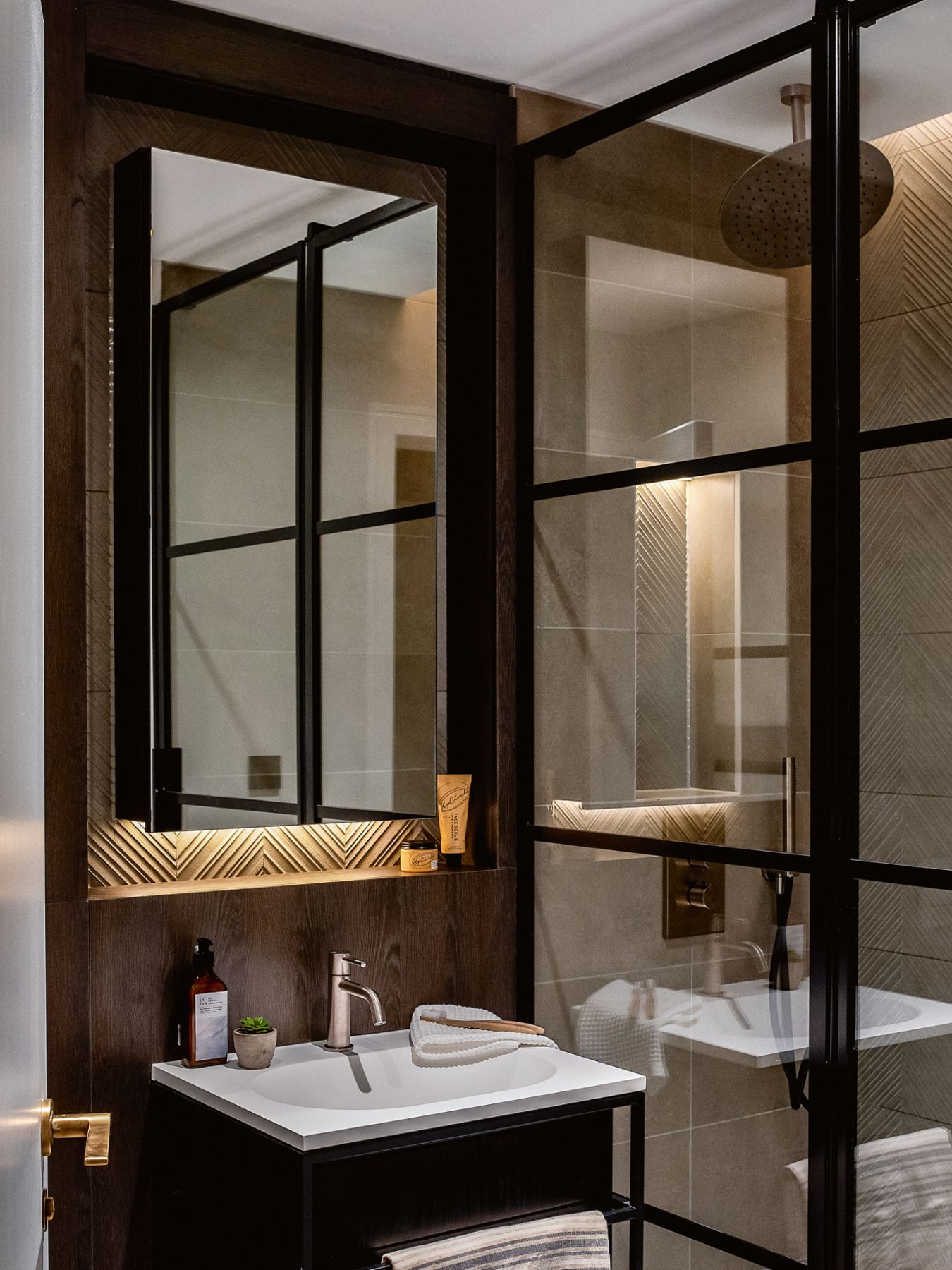 The chevron detailing of the mirrored cabinet adds a touch of the unexpected in this bathroom