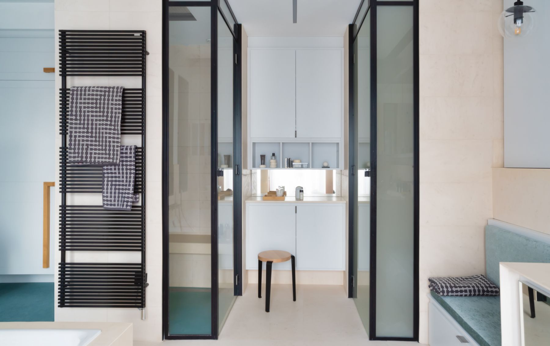 The black steel frames of the glass doors add a graphic edge to this nook in the bathroom