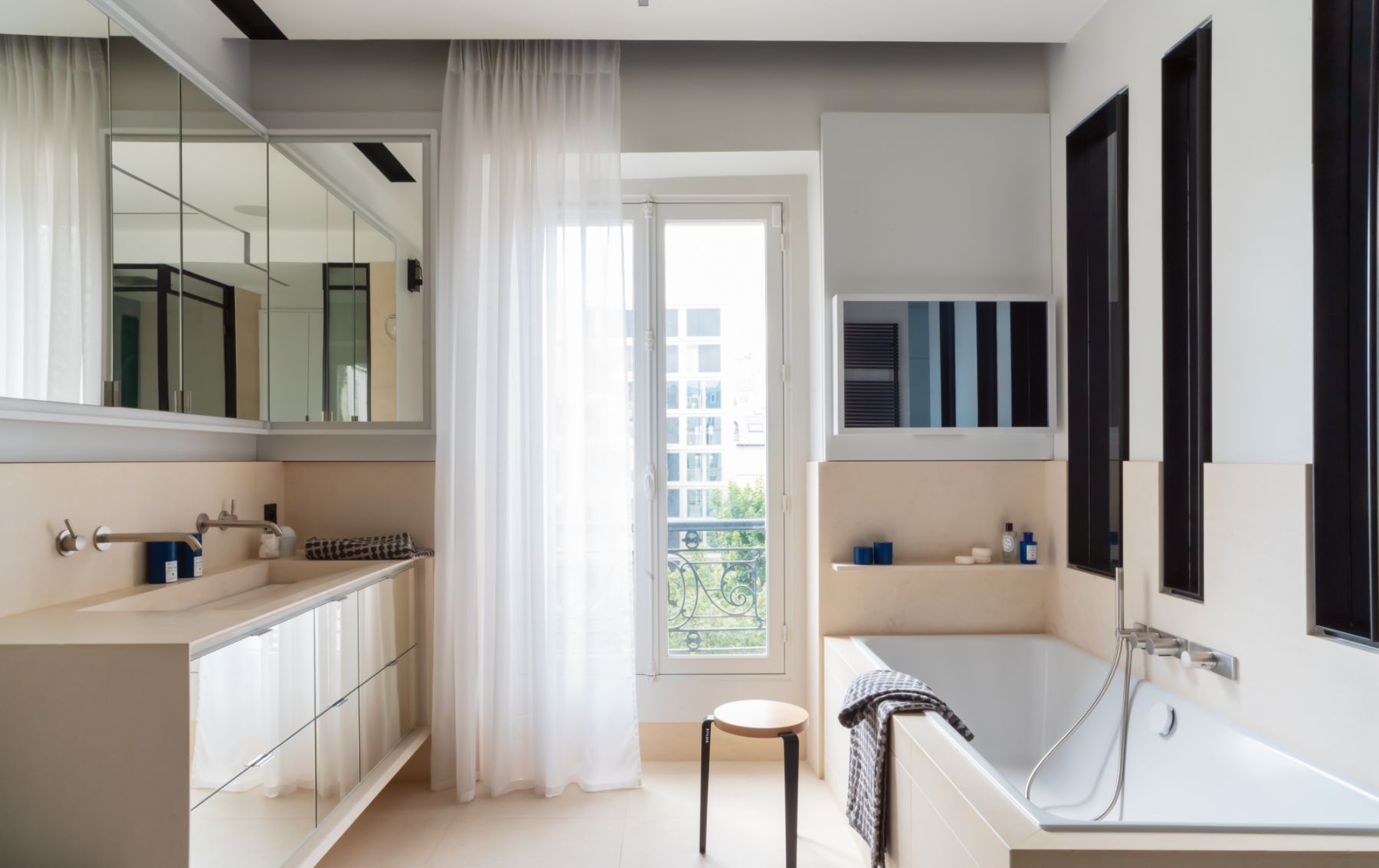Beige Portuguese stone applied to the walls and flooring contribute to the calming ambience of the master bathroom