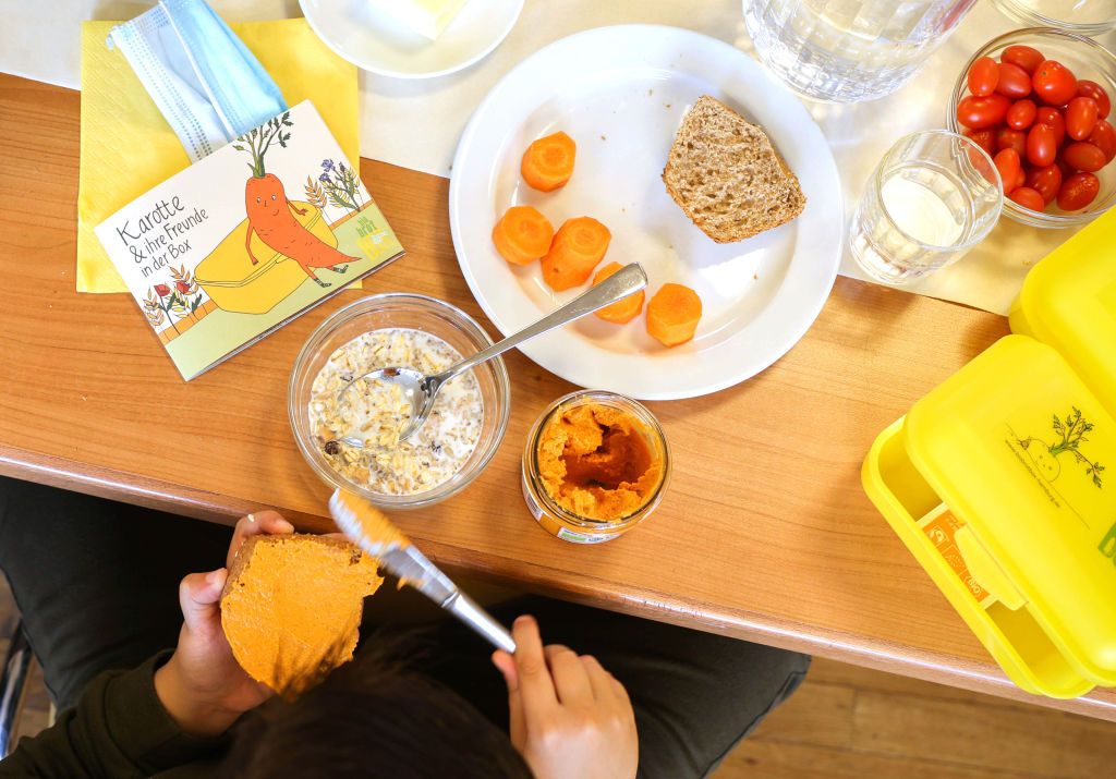 16 August 2021, Hamburg: A pupil spreads on a roll during a communal breakfast after the distribution of organic bread boxes at DempwolffstraÃe primary school in Hamburg-Harburg. This year, for the 15th time, the Bio-Brotbox Hamburg initiative is distributing its yellow Bio-Brotboxes to 231 schools in Hamburg. Photo: Christian Charisius/dpa (Photo by Christian Charisius/picture alliance via Getty Images)