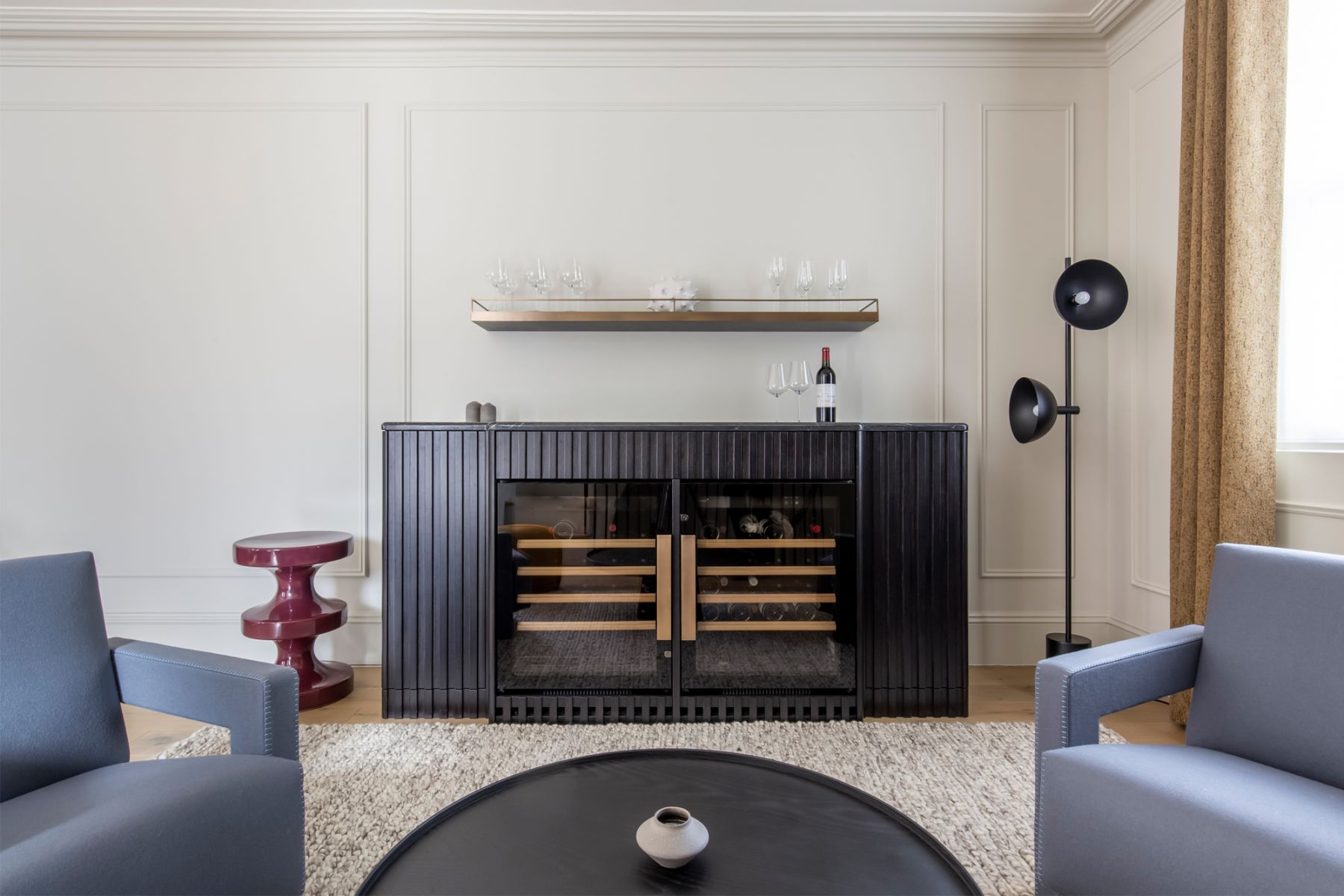 The bespoke drinks cabinet designed by TR Studio is crafted from charcoal black routed timber