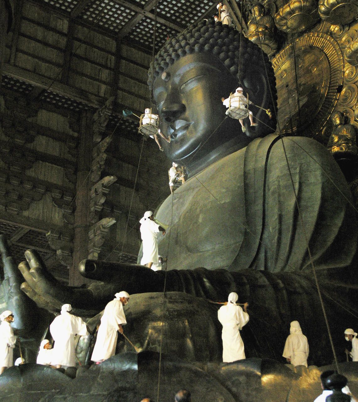 NARA, JAPAN - AUGUST 7: Cleaning gets underway on the 15-meter-high giant statue of Buddha of Todaiji Temple on August 7, 2004 in Nara, Japan. The Buddha, which was completed in AD 751, is being spruced up ahead the Buddhist festival period called bon. (Photo by Junko Kimura/Getty Images)