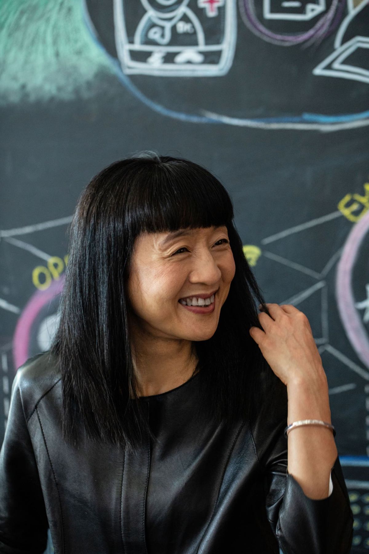 Cally Chan, GM of Microsoft Hong Kong and Macau, smiling in front of a chalkboard illustration
