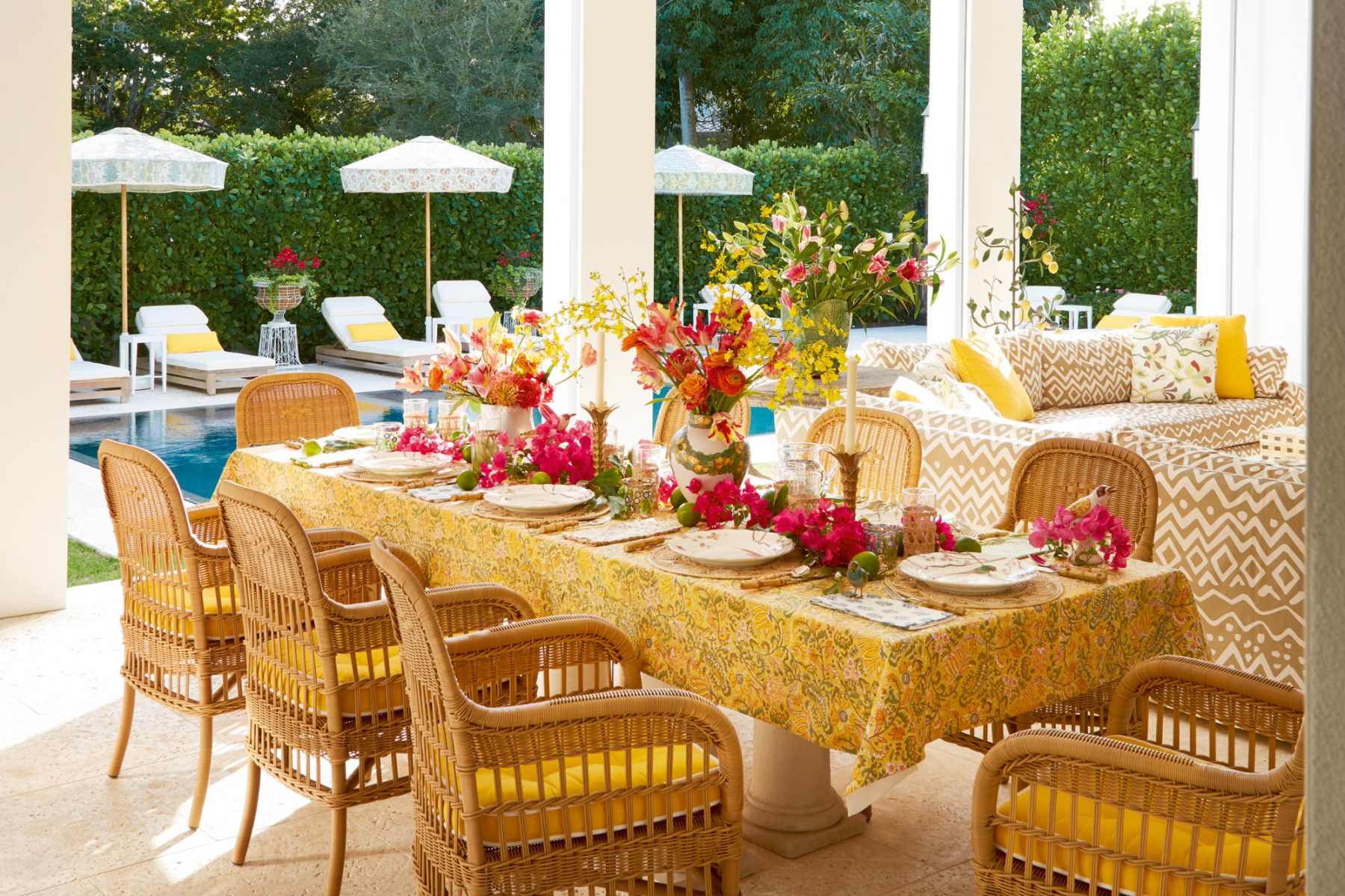 At the pool area, the eye is immediately drawn to lemon-yellow pillows sitting pretty atop creamy white and wood beach chairs