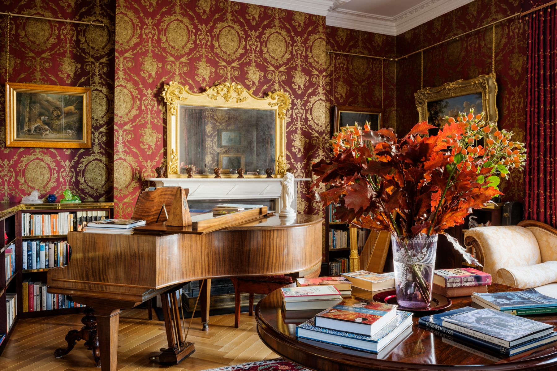 The music room on the ground floor features deep burgundy walls and houses the family's grand piano, harp and a collection of guitars