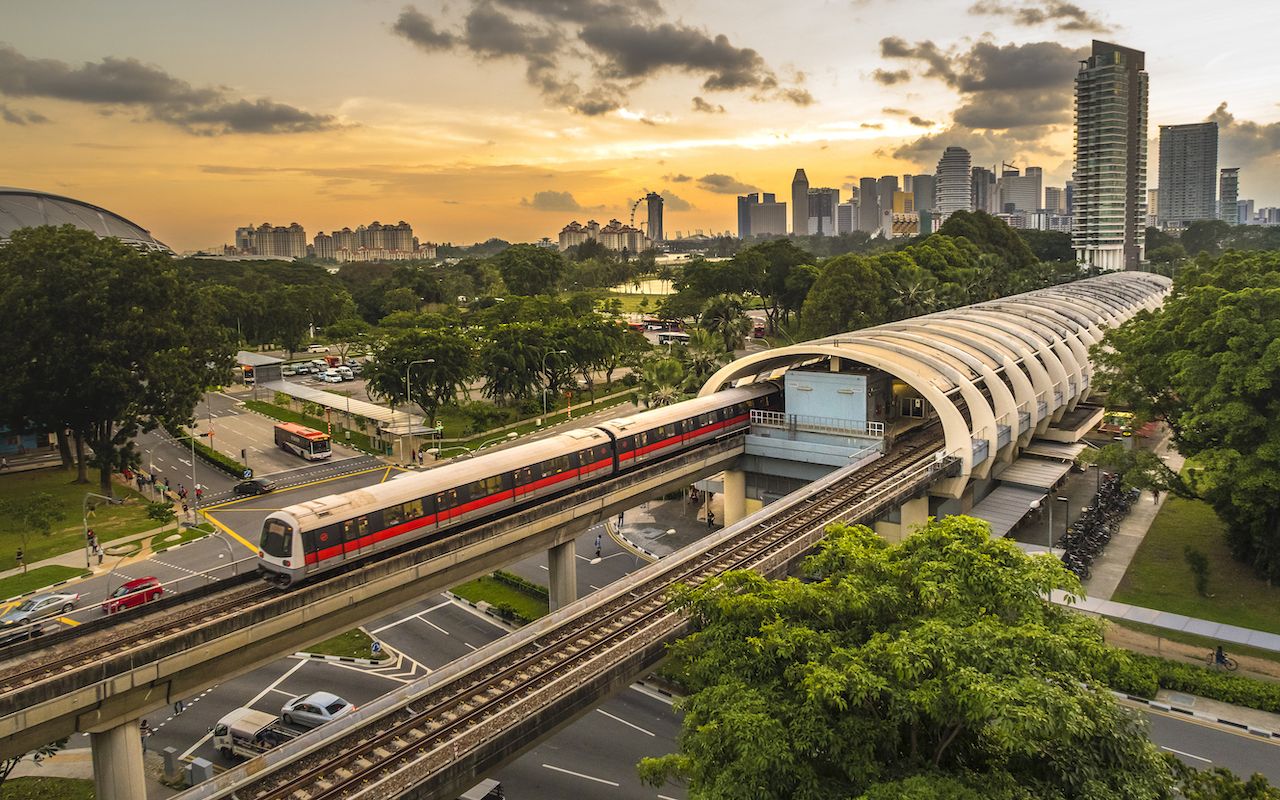 A view of Singapore mass rapid transit  (MRT) train service in central Kallang station during sunset with Singapore city skyline in background. Singapore MRT train system serves as one of Singapore daily transportation for most commuters