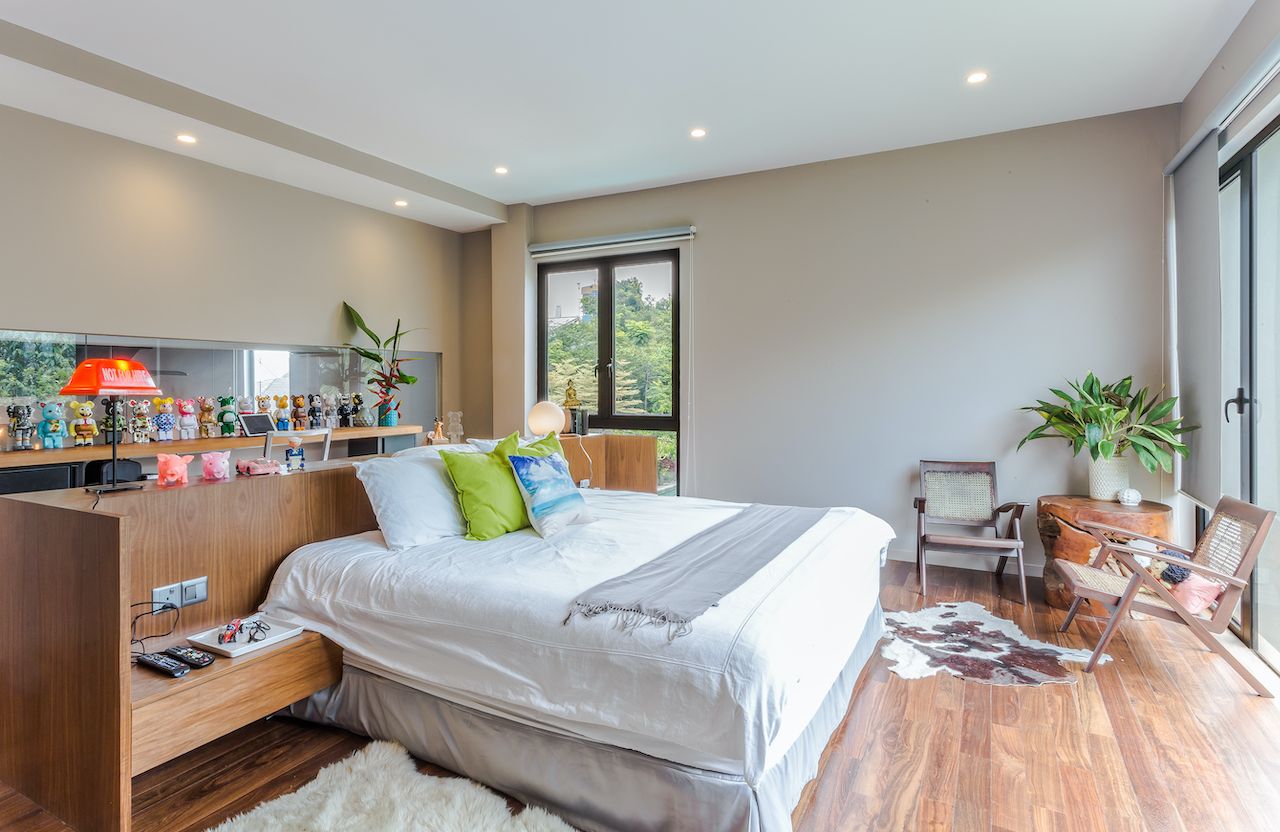 The homeowners can peek into the master bedroom in the level below via a horizontal glass panel behind the headboard