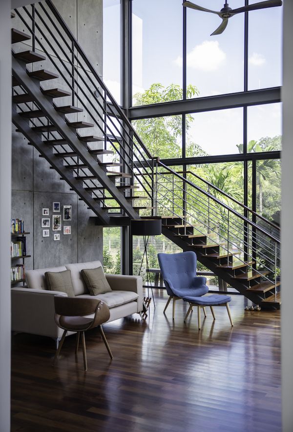 The double height living room offers a generous view of the lush surroundings