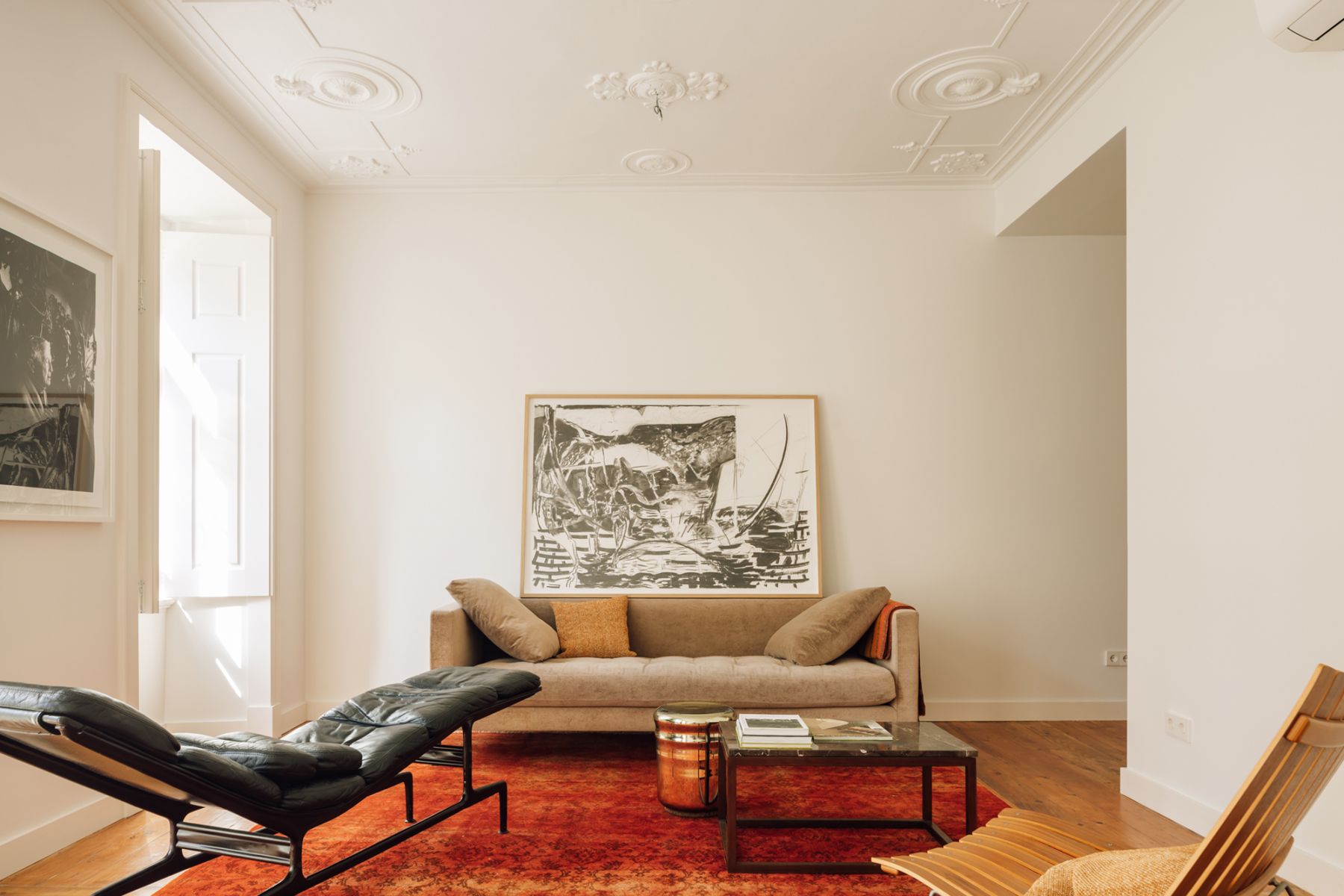 The open-plan living room is a cosy space with plenty of natural light flooding in from the full-height windows