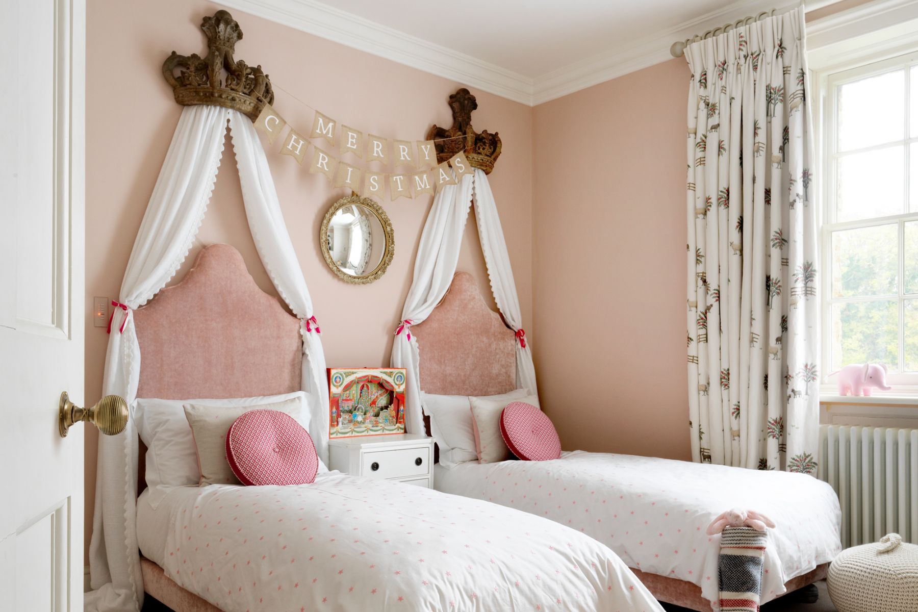 The daughter's pink bedroom features a pair of coronets that form the centrepiece, each is hung with a flowing muslin drape trimmed with Samuel & Sons Lancaster Fan Edge and tied with satin ribbons