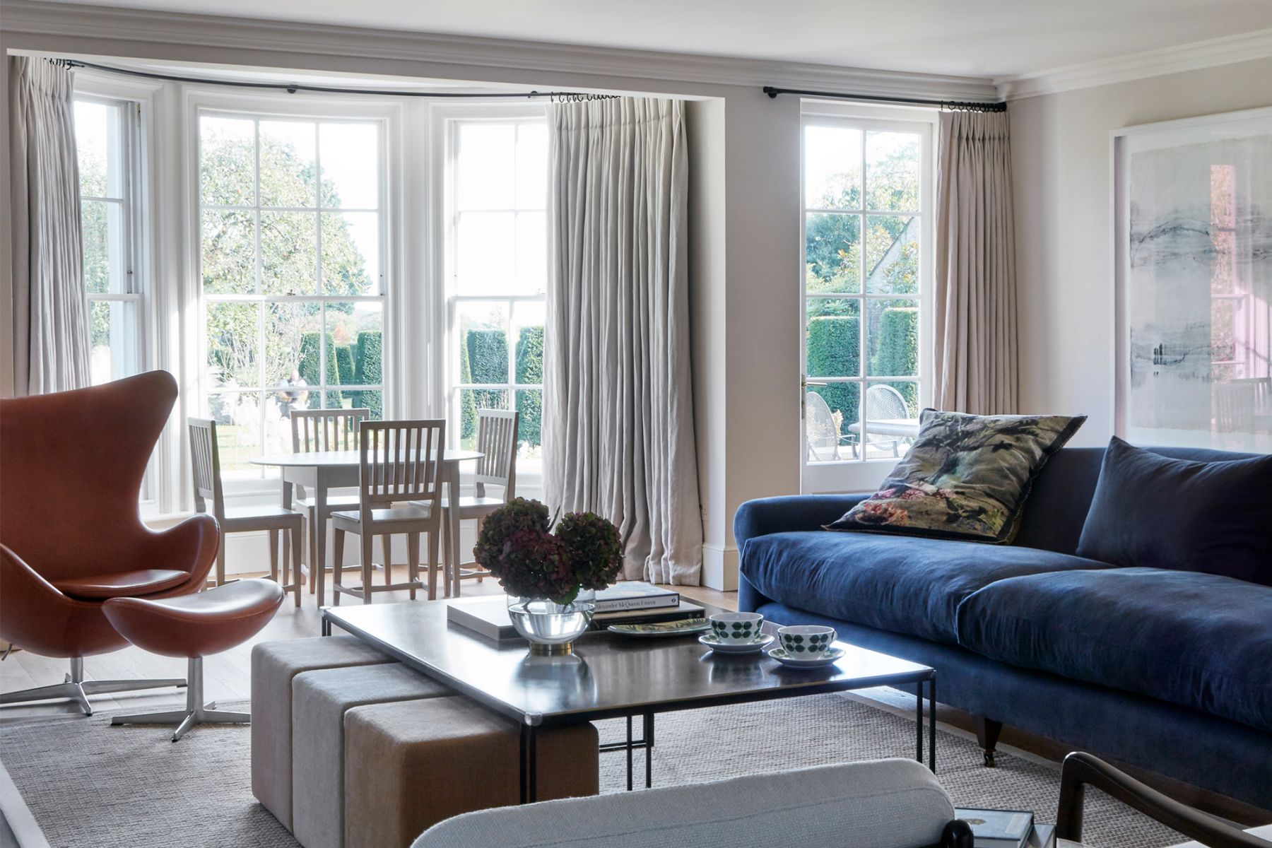 The living room features soft furnishings in rich tones, adding a layer of style to the space