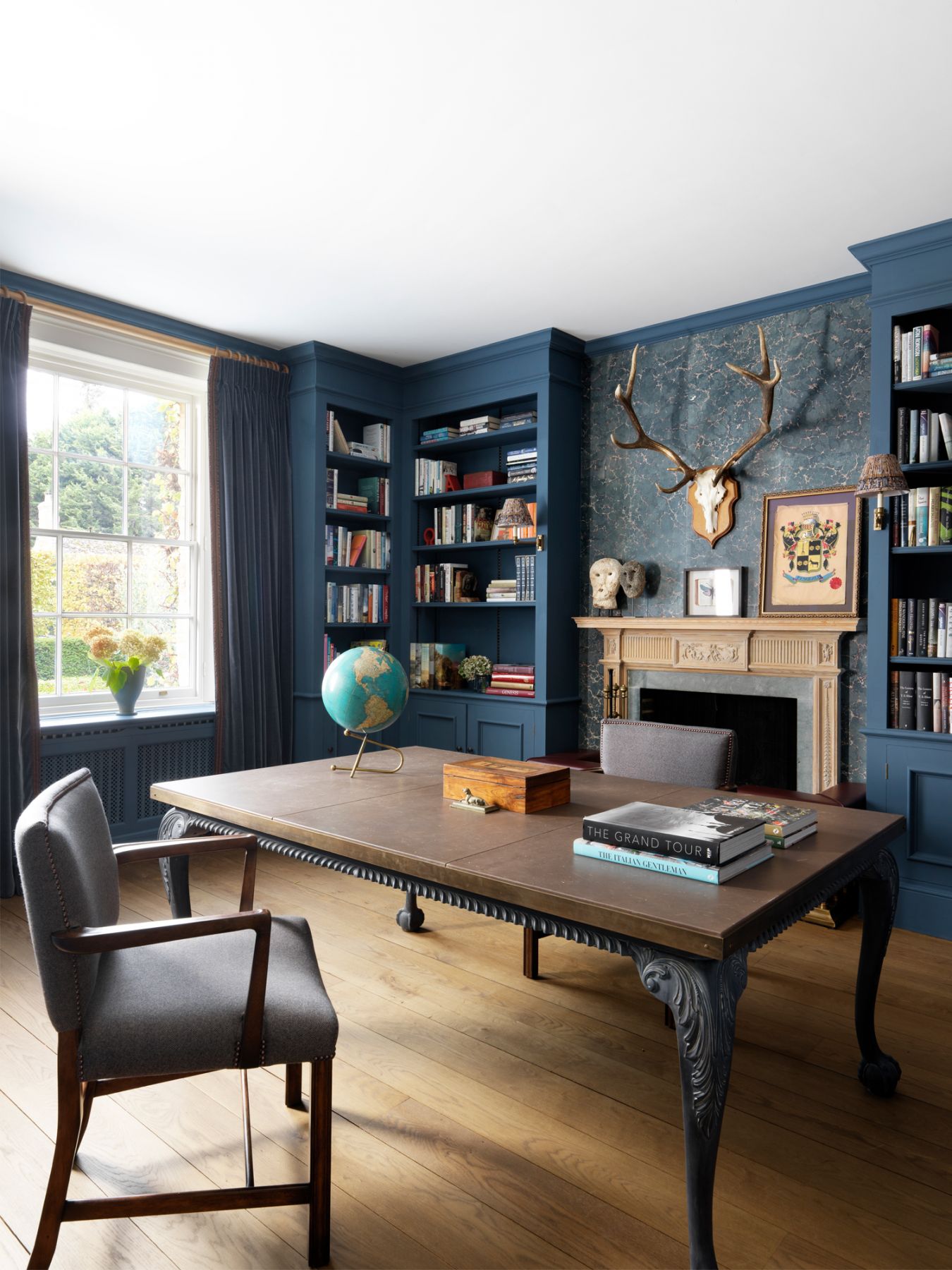 The study features a bespoke table crafted by K&H Design, who paired distressed table legs with a leather inset table top with brass accents made to size
