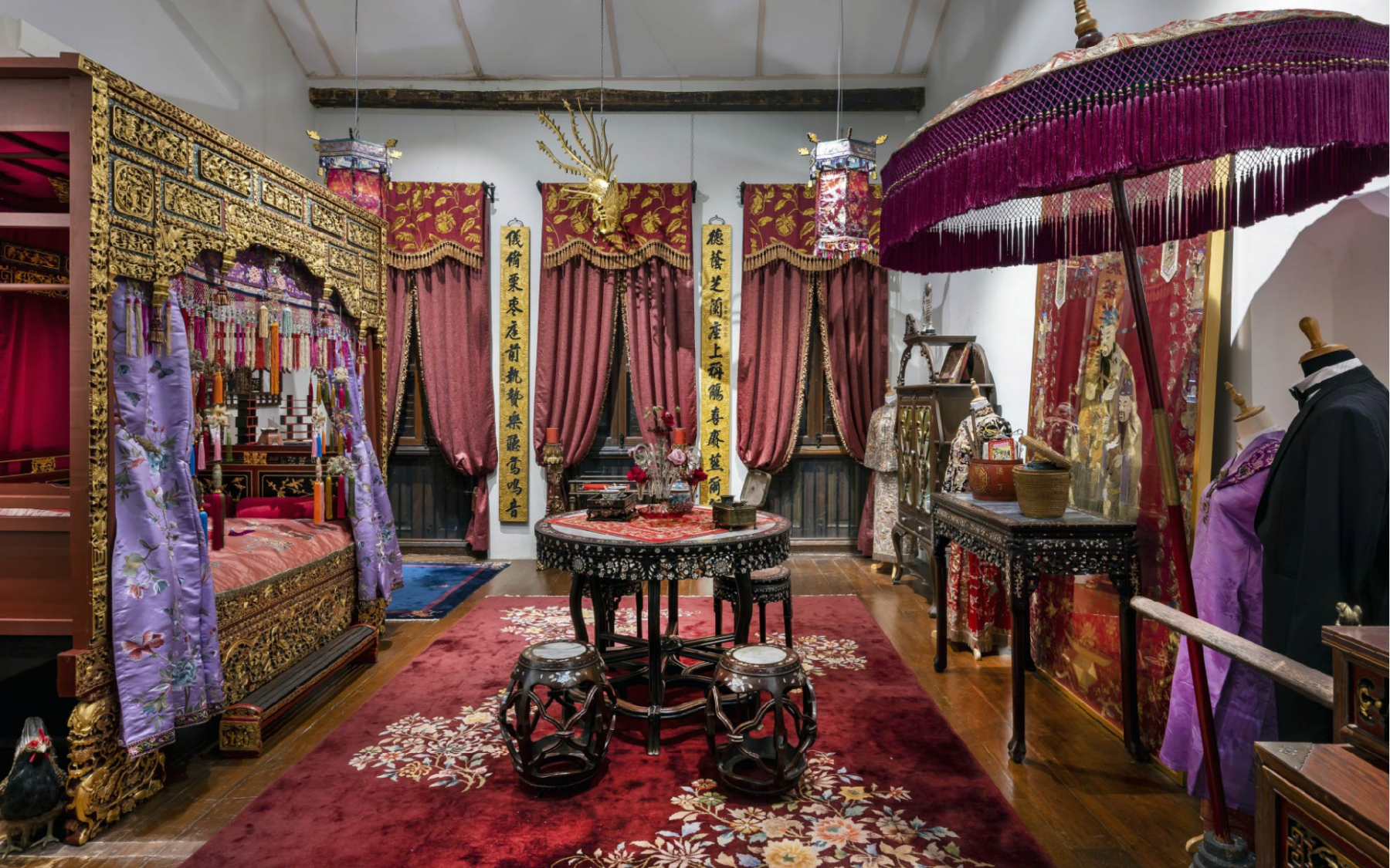 The dramatic scarlet bedroom is congruent with the flamboyant style which the wealthy Straits Chinese families lived.