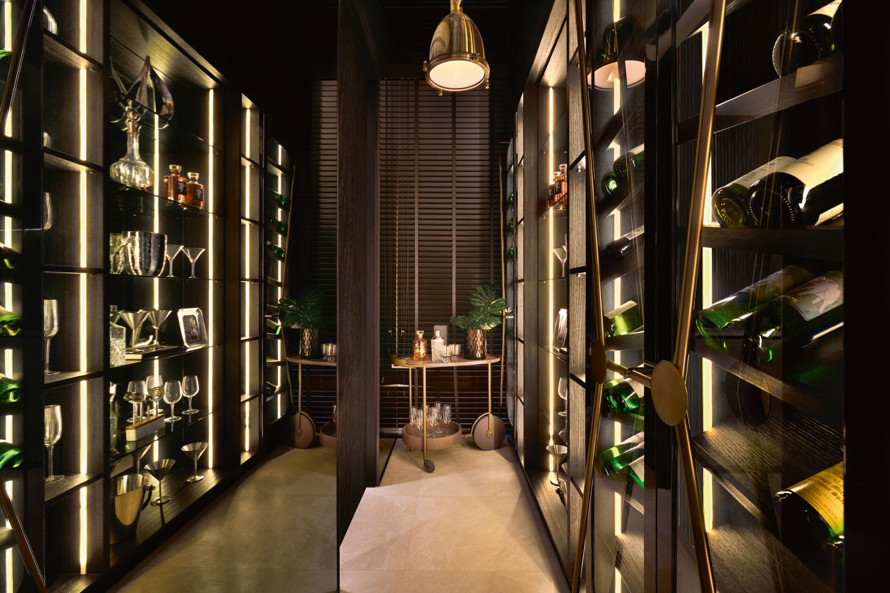 The mix of dark wood cabinetry, metallic details, mirrored panels and backlit shelves contributes to this wine room’s polished look