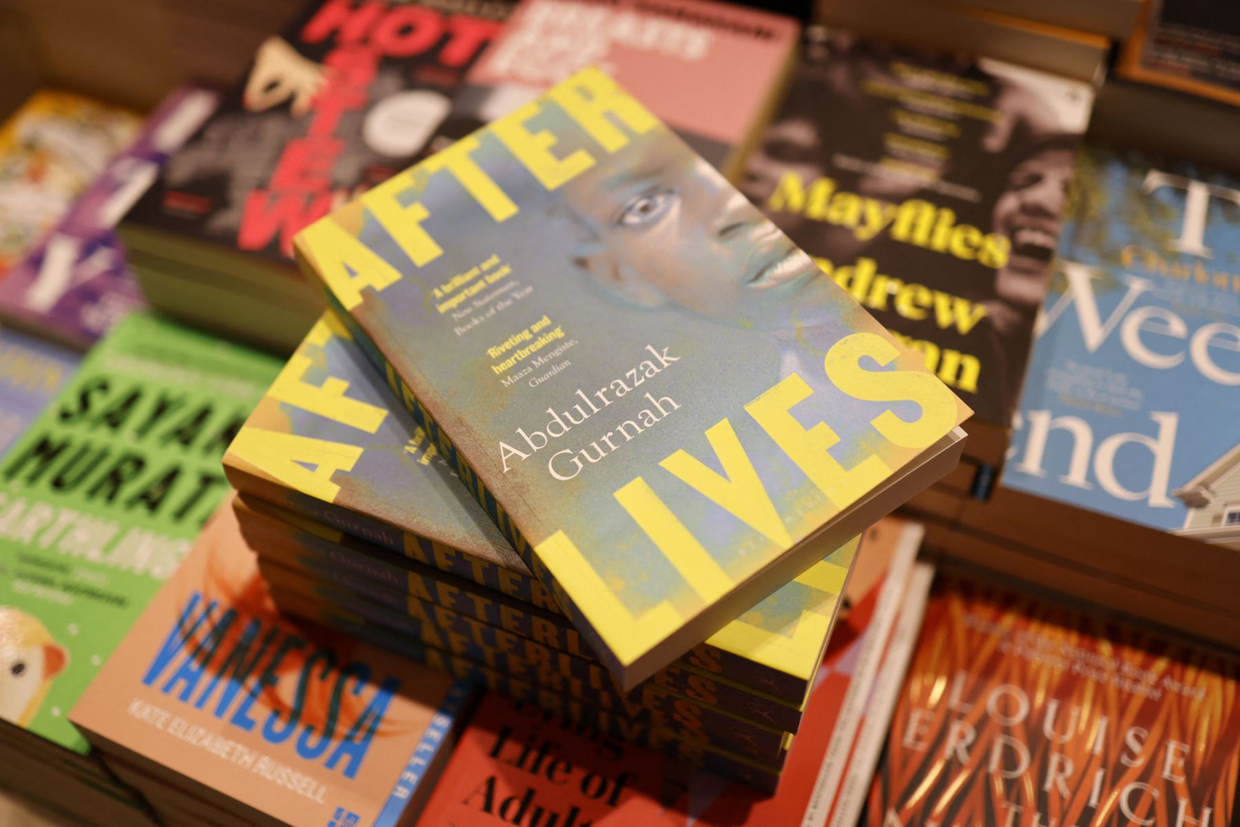 Copies of "Afterlives" by Tanzanian-born novelist Abdulrazak Gurnah are displayed at Waterstones bookshop in central London on October 7, 2021. - Tanzanian-born novelist Abdulrazak Gurnah, whose work focuses on colonialism and the trauma of the refugee experience, won the Nobel Literature Prize. (Photo by Tolga Akmen / AFP)