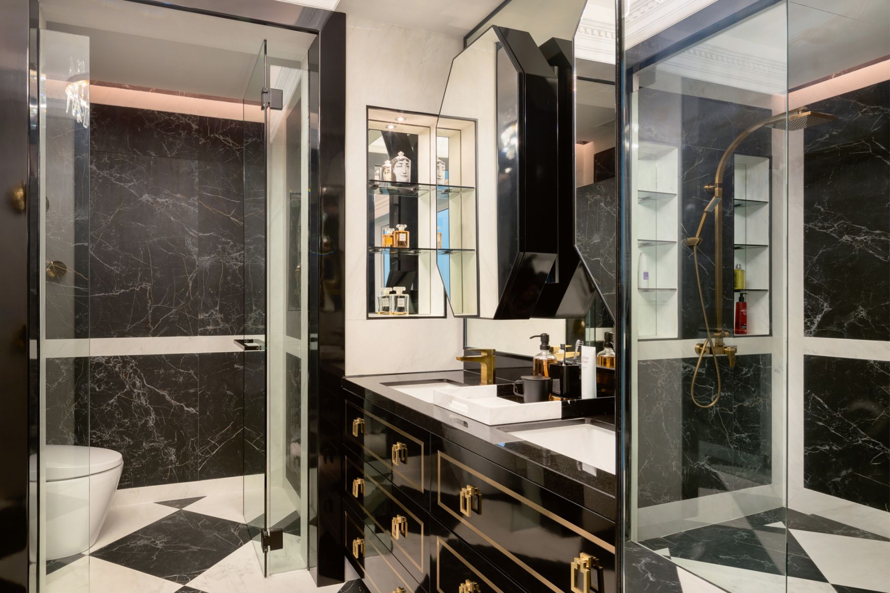 Octagonal mirrors, glossy black cabinetry and gold hardware contribute to the glamorous look of the master bathroom