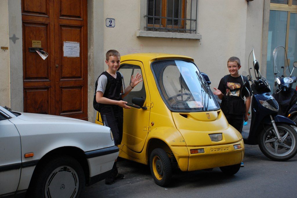 Josianne Robb's sons with a small yellow car on a street in Italy