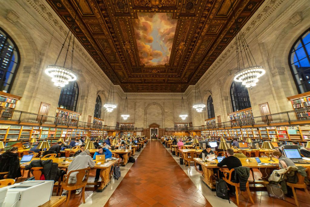 Inside the Rose Main Reading Room, the main reading room with side books and large windows, officially Room 315 on the third floor, a room 78 x 297 feet and 52 foot high wooden carved ceiling in a style between Renaissance architectural style and Beaux-Arts design in the Stephen A. Schwarzman Building, commonly known as the Main Branch. New York Public Library Main Branch in Bryant Park, Manhattan, NYPL, is the third largest library in the world. The branch was declared a National Historic Landmark in 1965