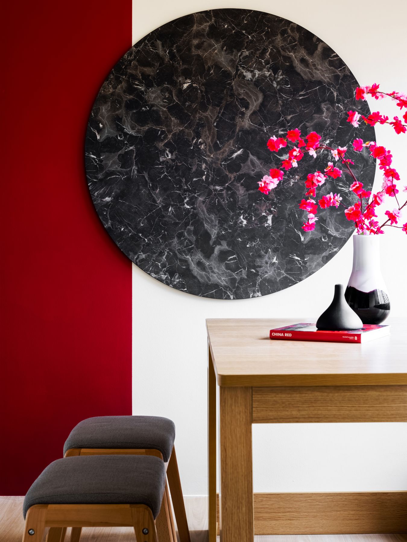 An artwork hung on the feature wall as well as vibrant flower arrangements add a pop of colour to the home