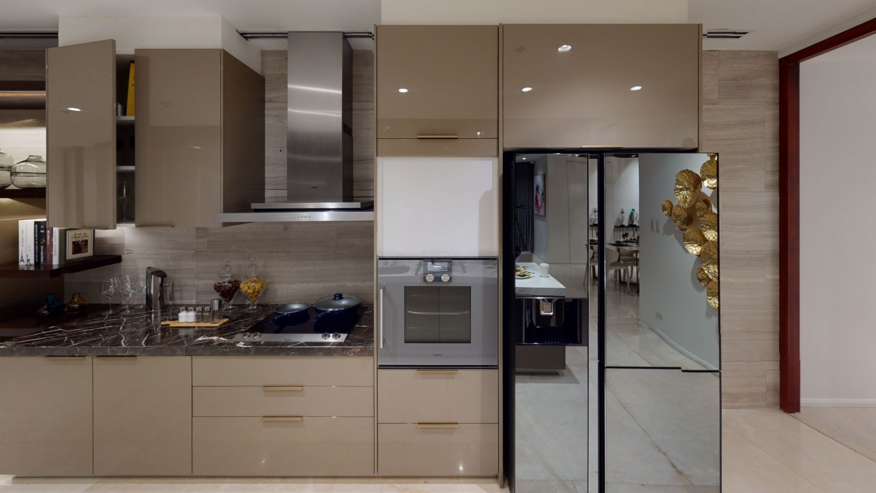 The Show Kitchen of 3 Bedroom with Den Units feature Gaggenau chimney-type Rangehood, cooktop, and built-in oven, as well as a high-end refrigerator.