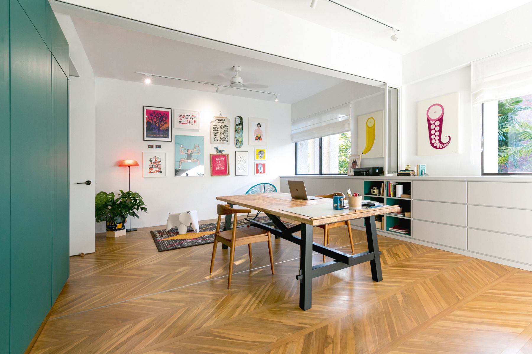 A gallery wall jazzes up the owner’s workspace, where she keeps her art supplies and other creative tools well organised in sleek white cabinets