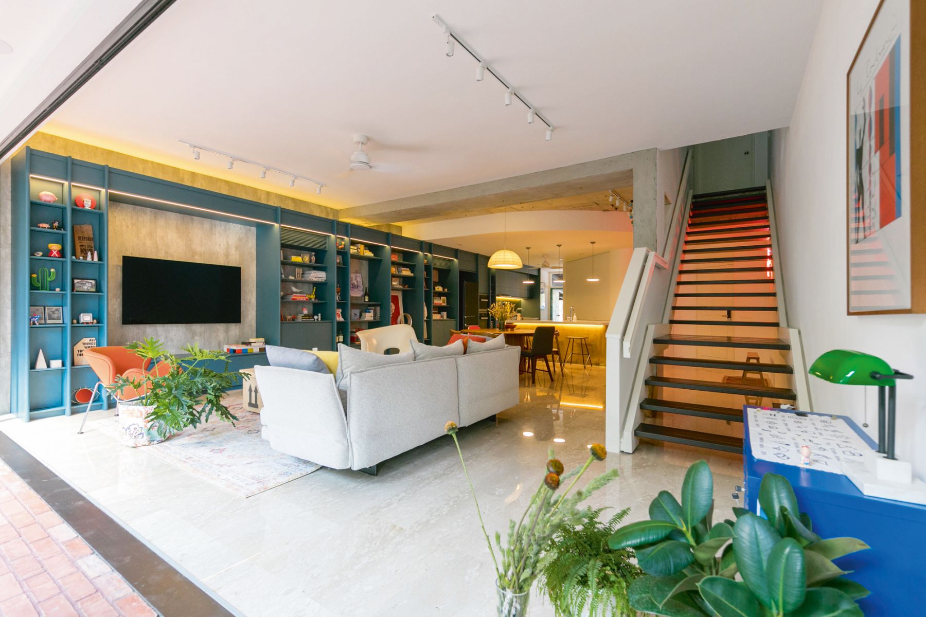 The teal cabinetry in the living area is paired with accent pieces and art in contrasting colours