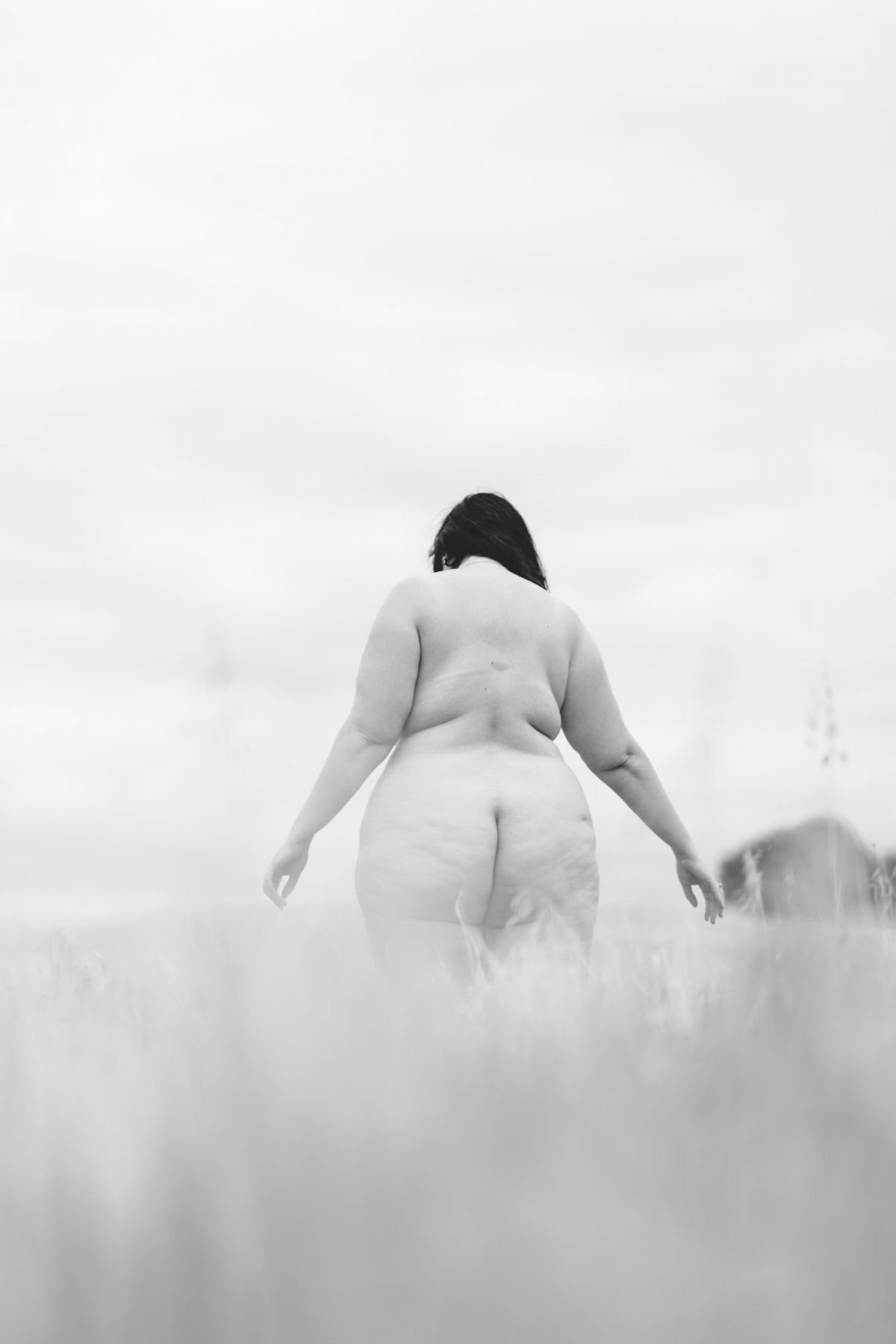 The naked backside of a woman in a field, photographed by Stephanie Teng