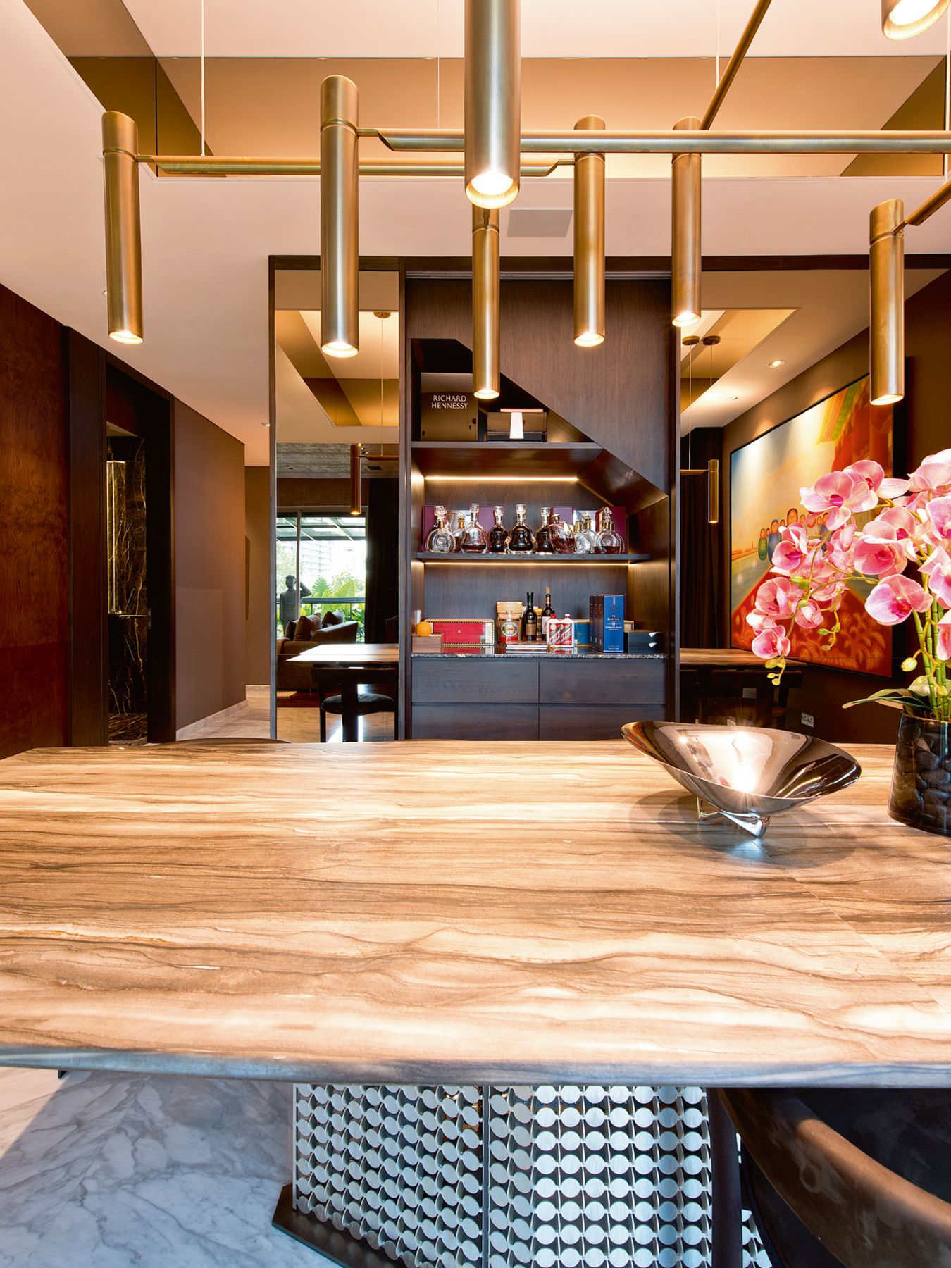A Pan De Hai painting adds vibrancy to the dining area, which is furnished with a Henge S-Penny dining table by Massimo Castagna