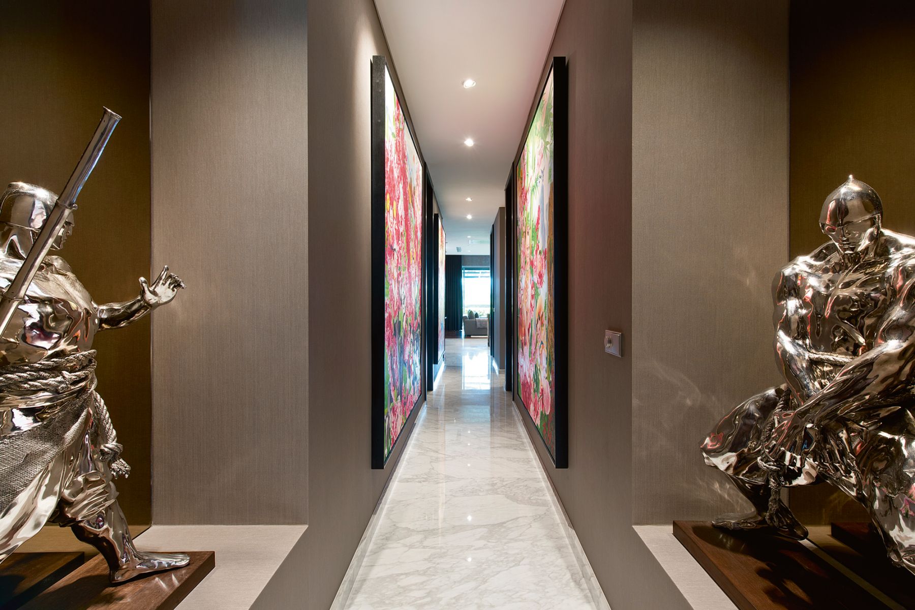 Stainless-steel sculptures by Ren Zhe stand before a dramatic corridor flanked by colourfully oversized artworks